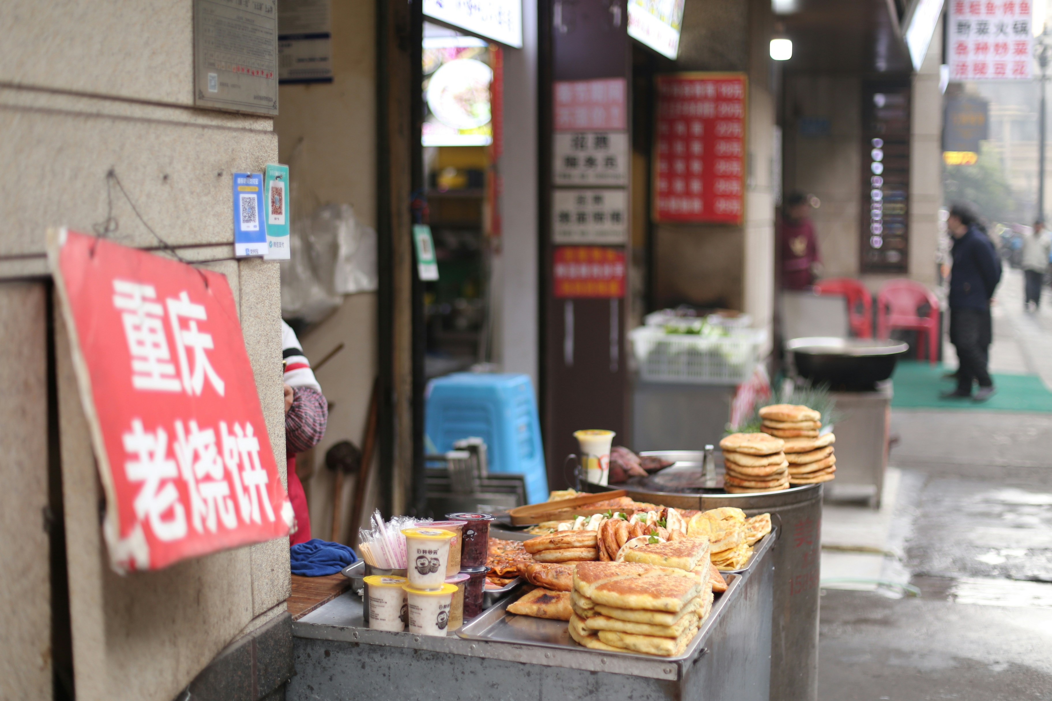 Street food stall with stacked flatbreads and signage.