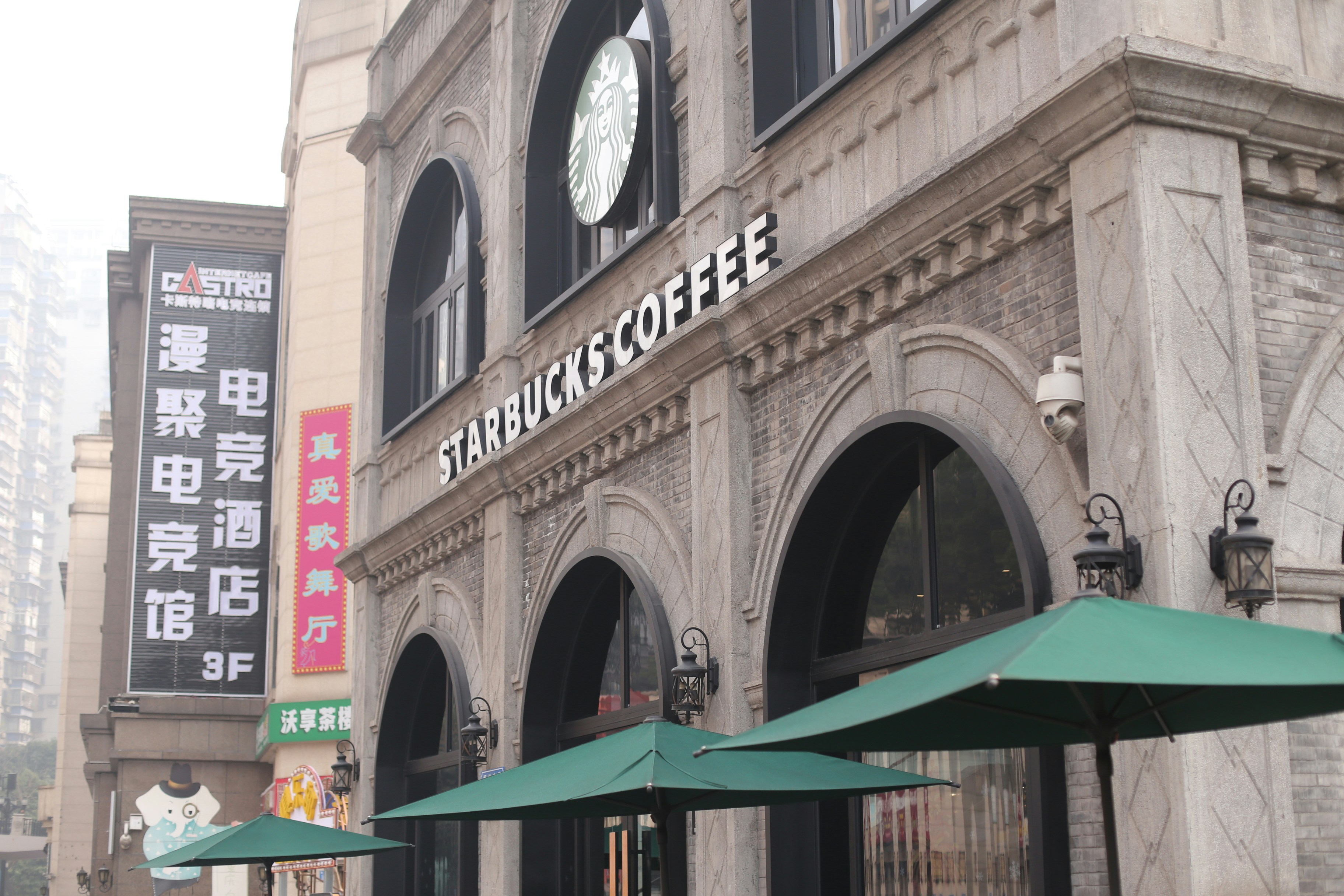 Starbucks cafetería con paraguas verdes en el exterior