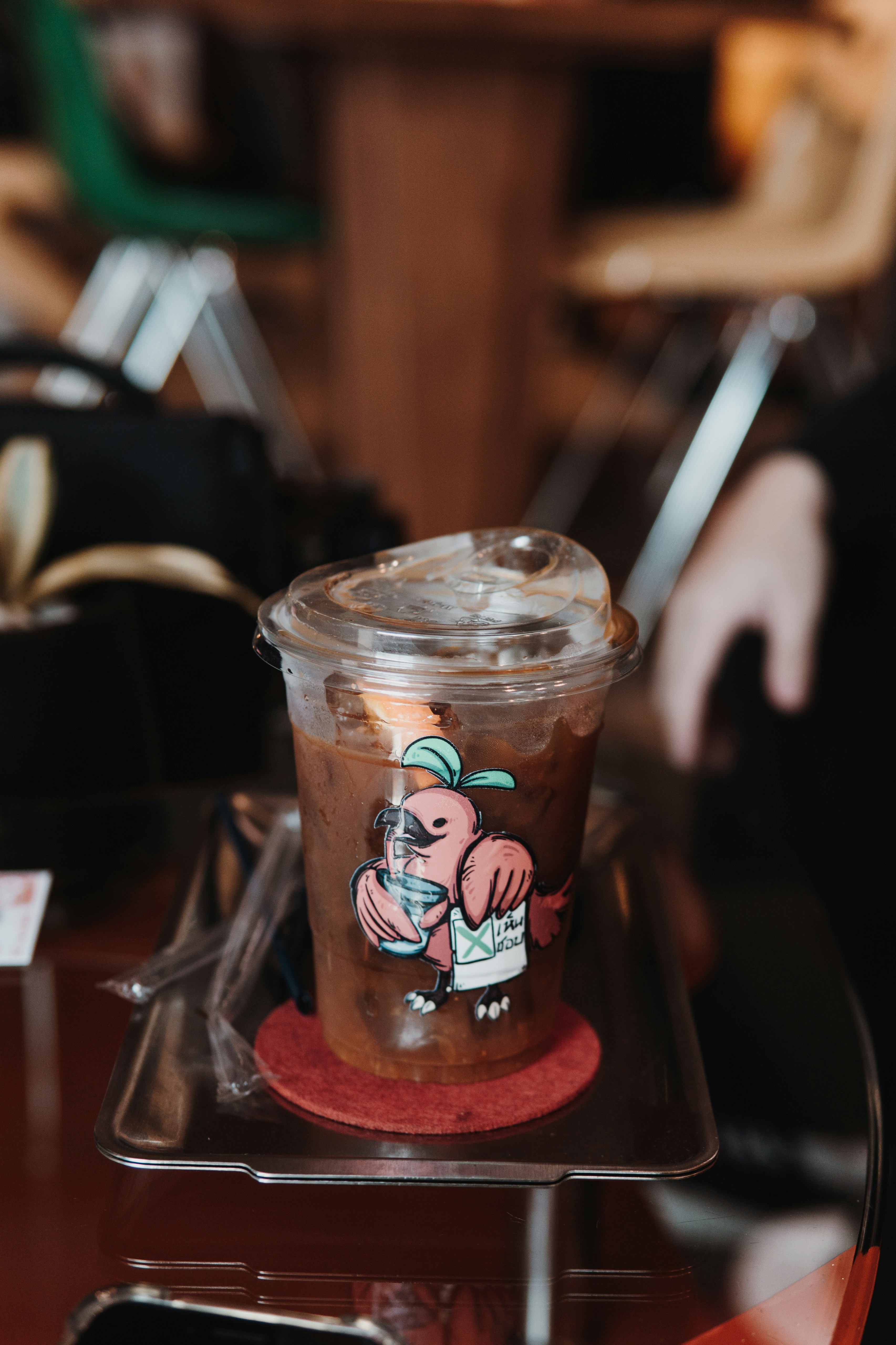 Iced coffee in a plastic cup with cartoon bird sticker
