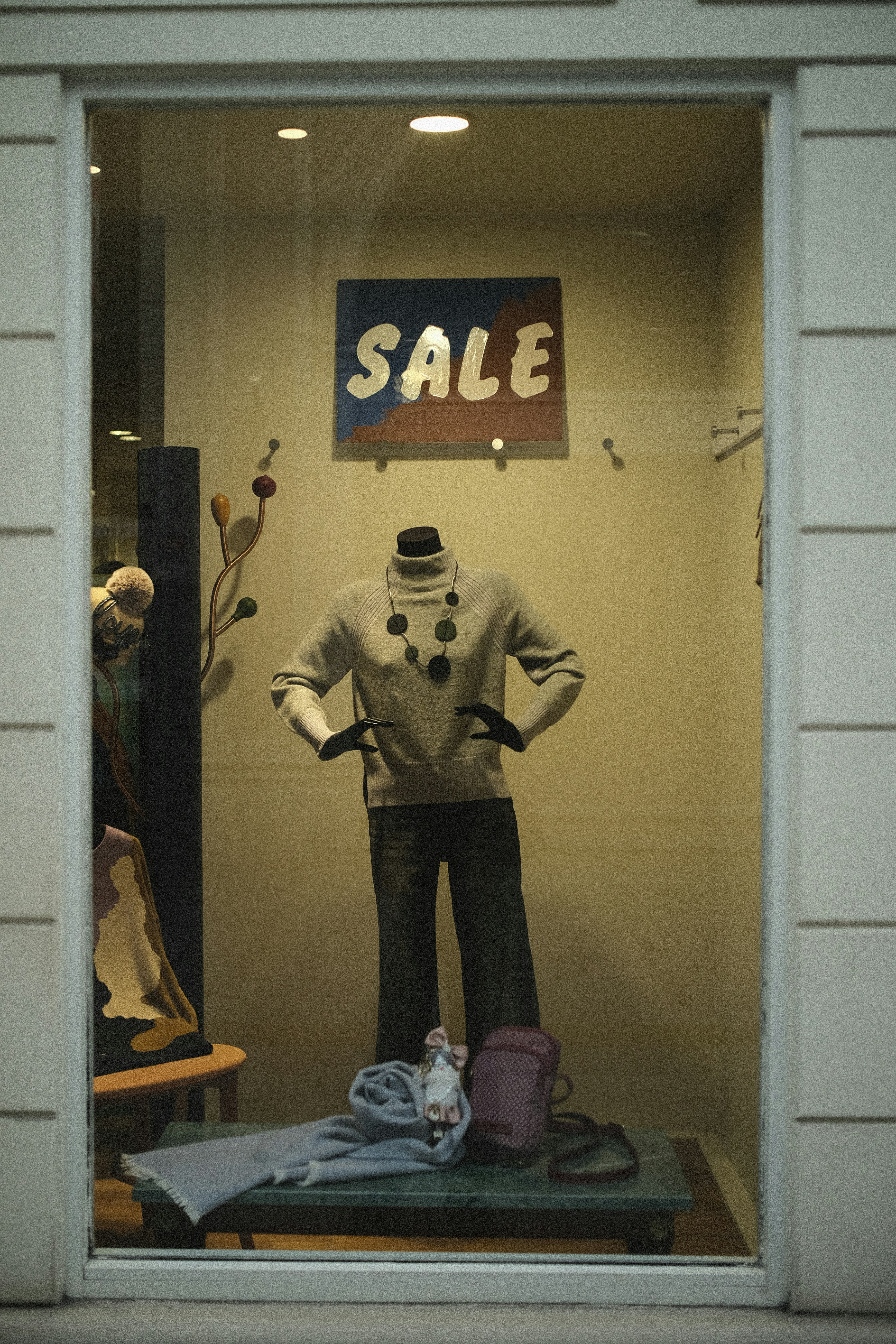 Mannequin in store window with sale sign