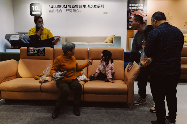 People gathered around a sofa in a showroom.