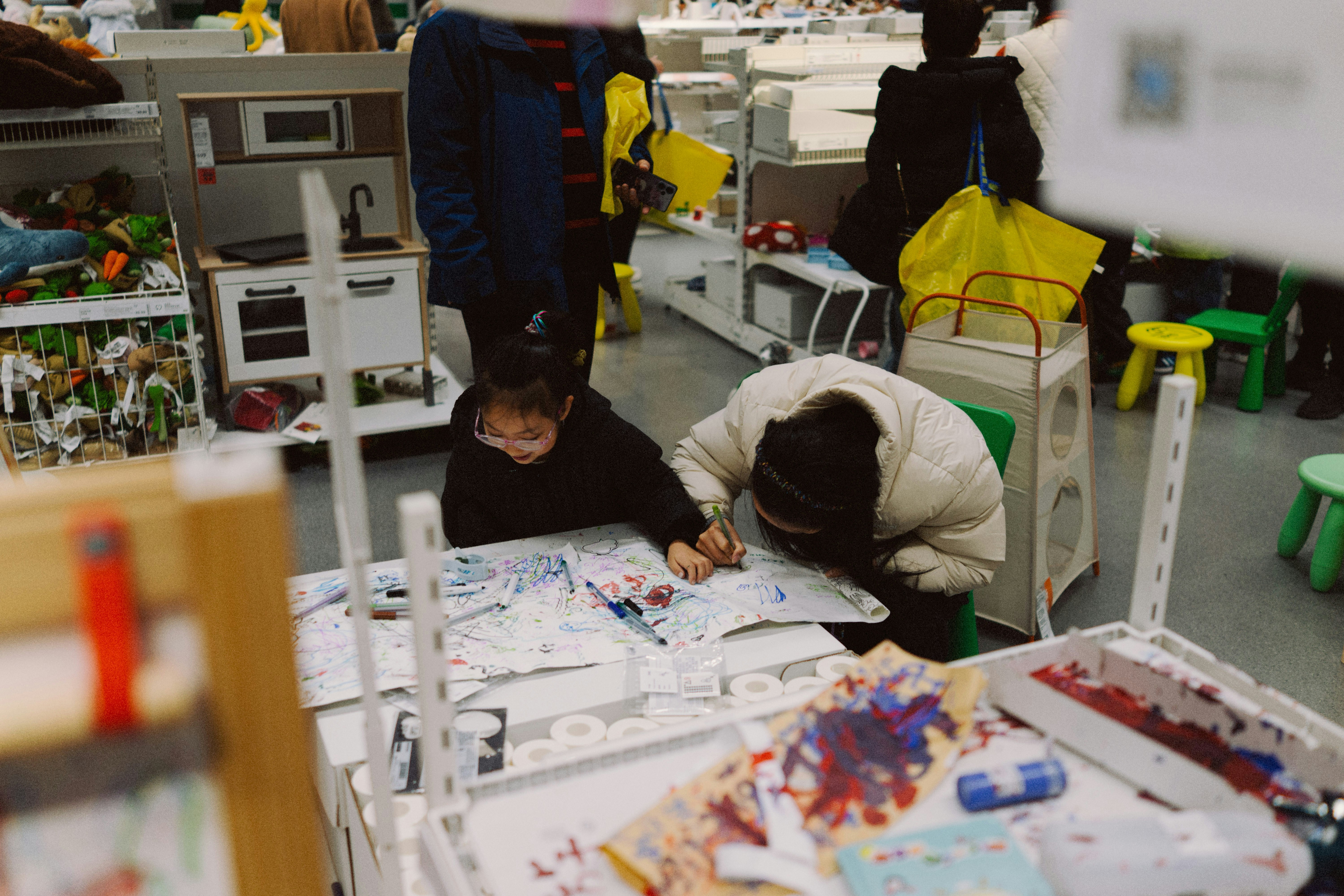 Two children drawing and painting at a table.