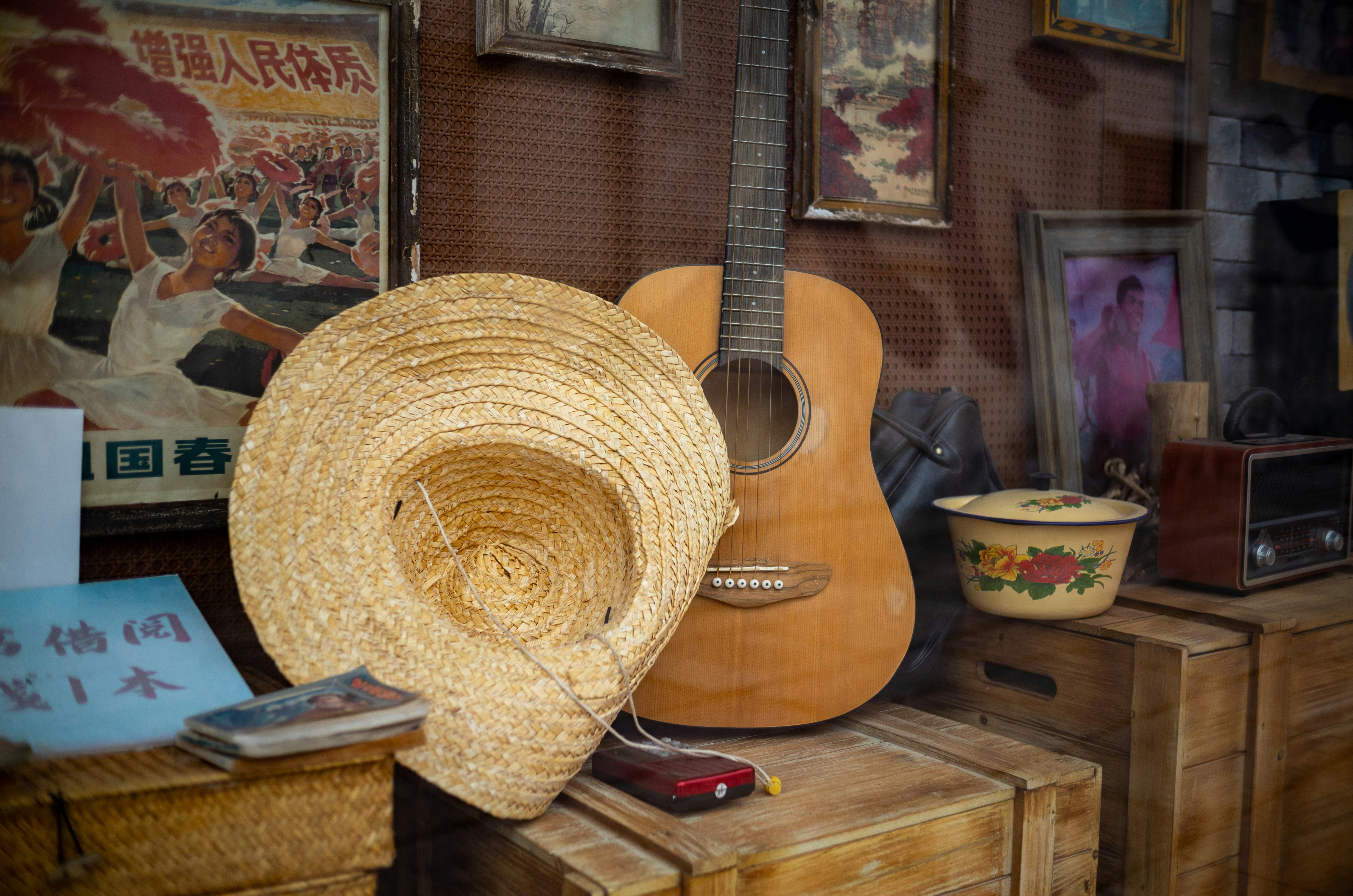 Ein Strohhut und eine Gitarre auf Holzkisten