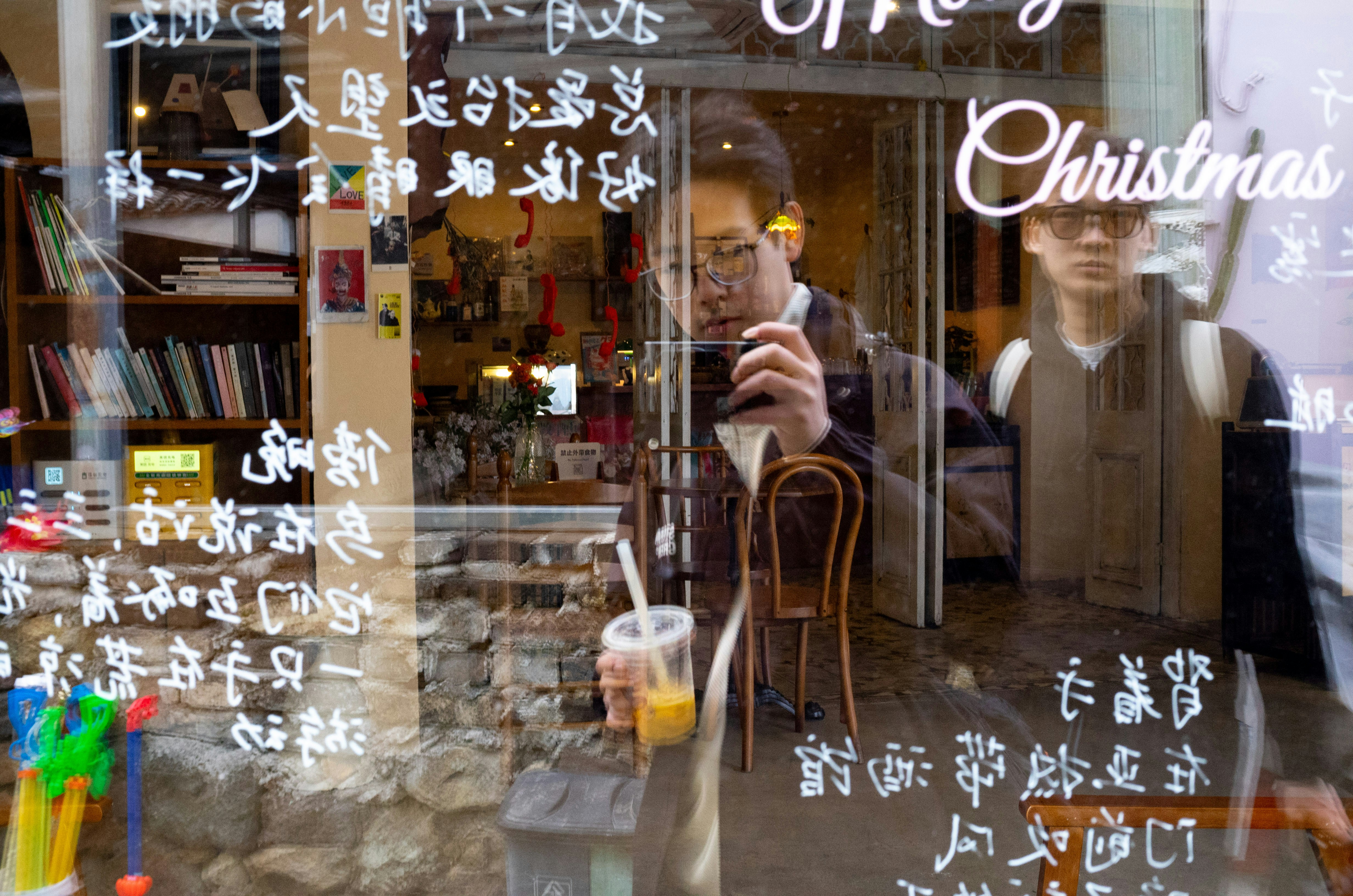 Man reflected in a shop window with christmas decorations
