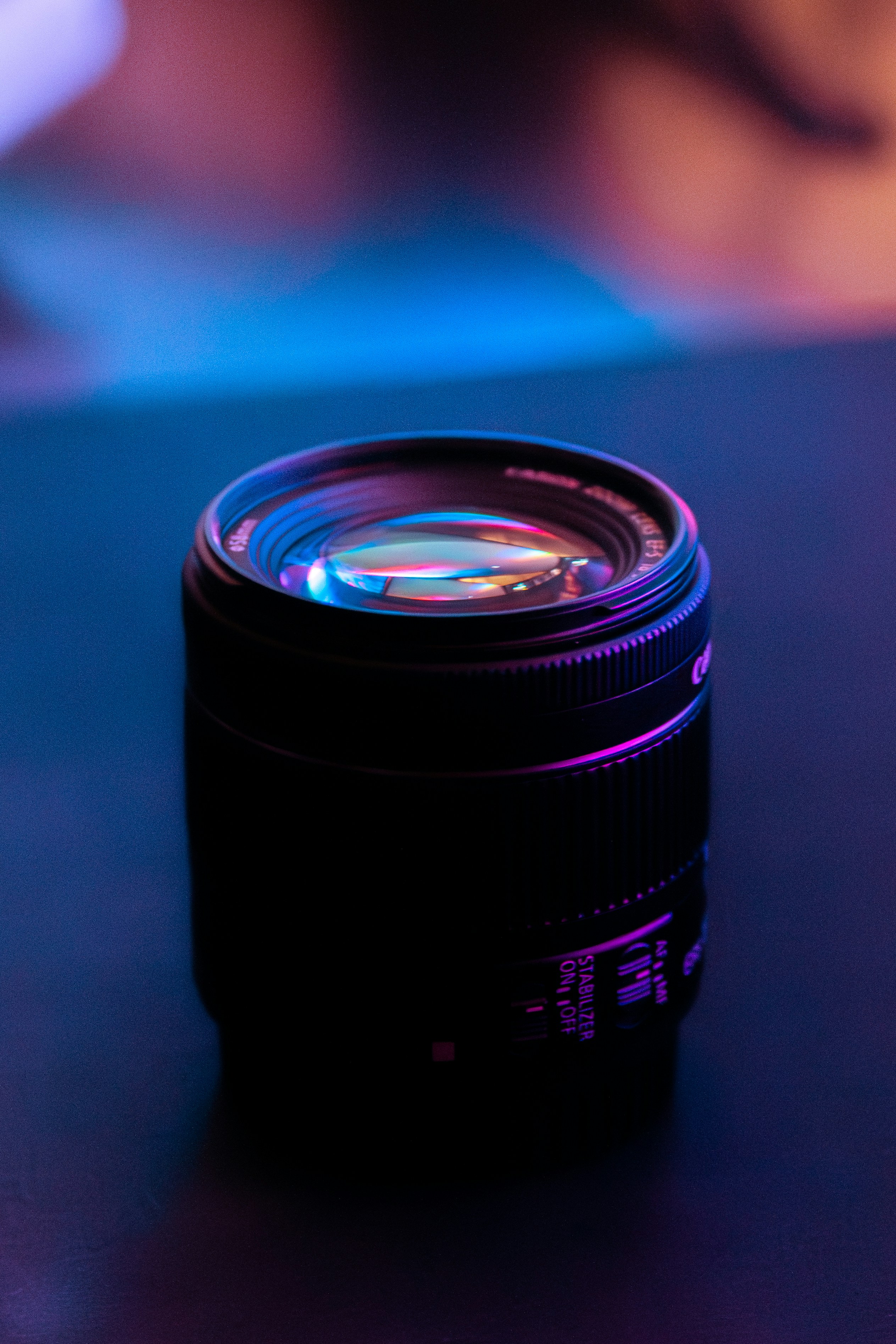 A black camera lens with colorful lighting