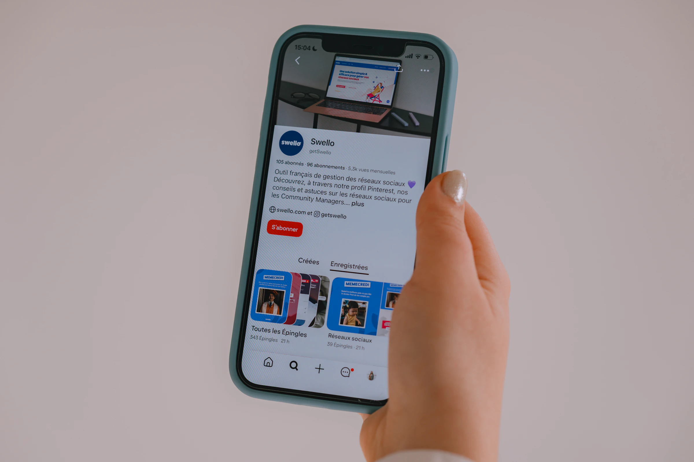 Hand holding a smartphone with a social media feed on screen, representing mobile engagement
