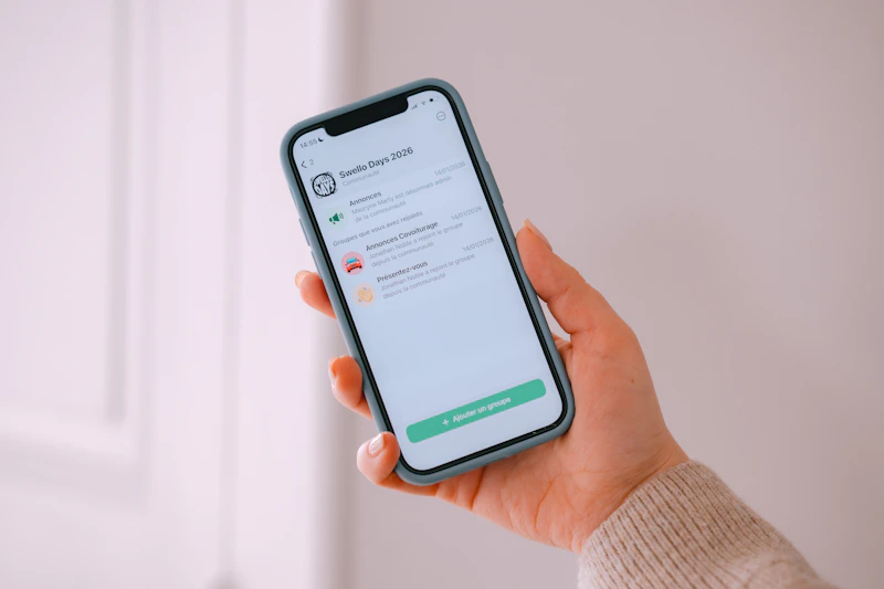 Hand holding a smartphone displaying a mobile application