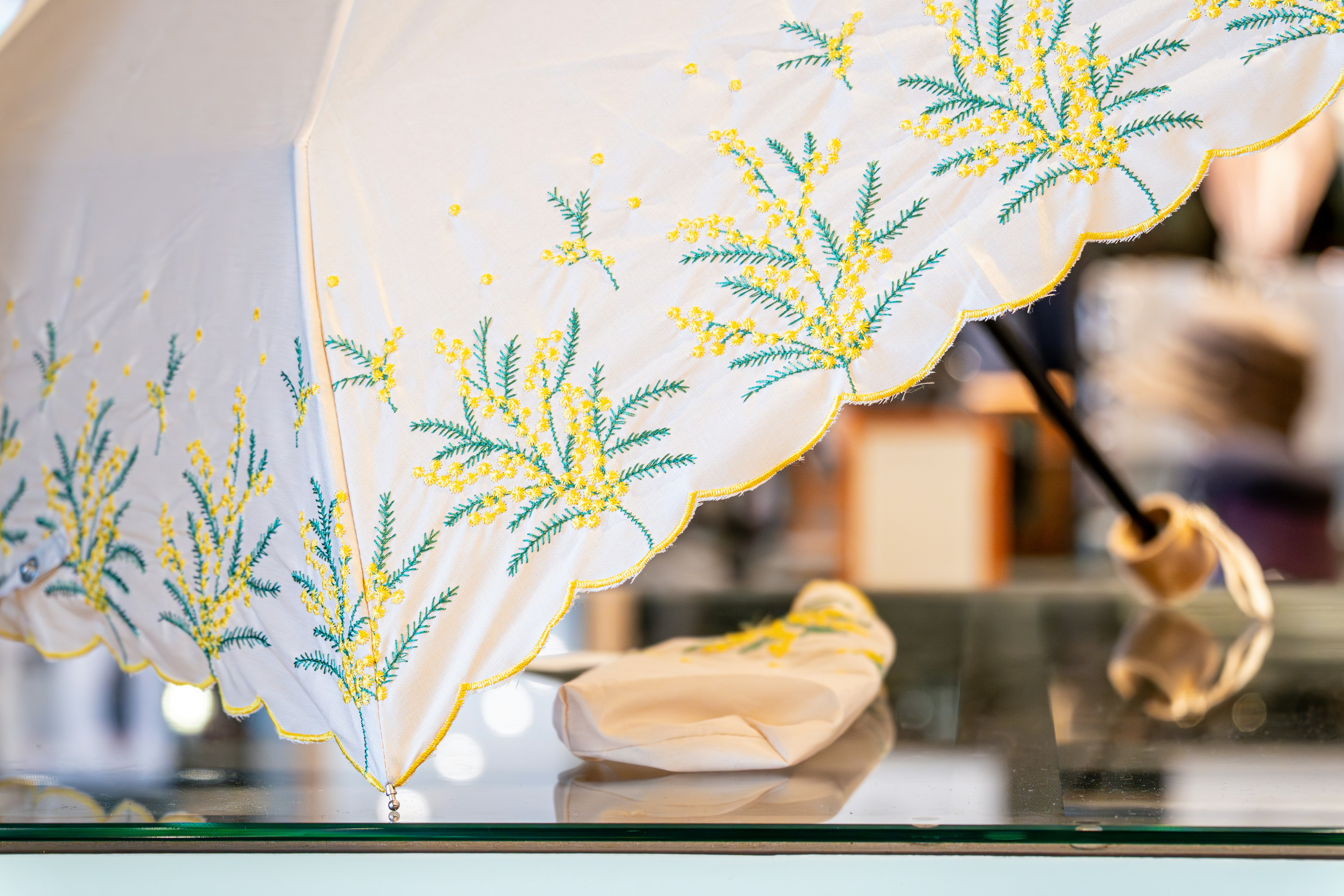 White umbrella with yellow and green floral embroidery