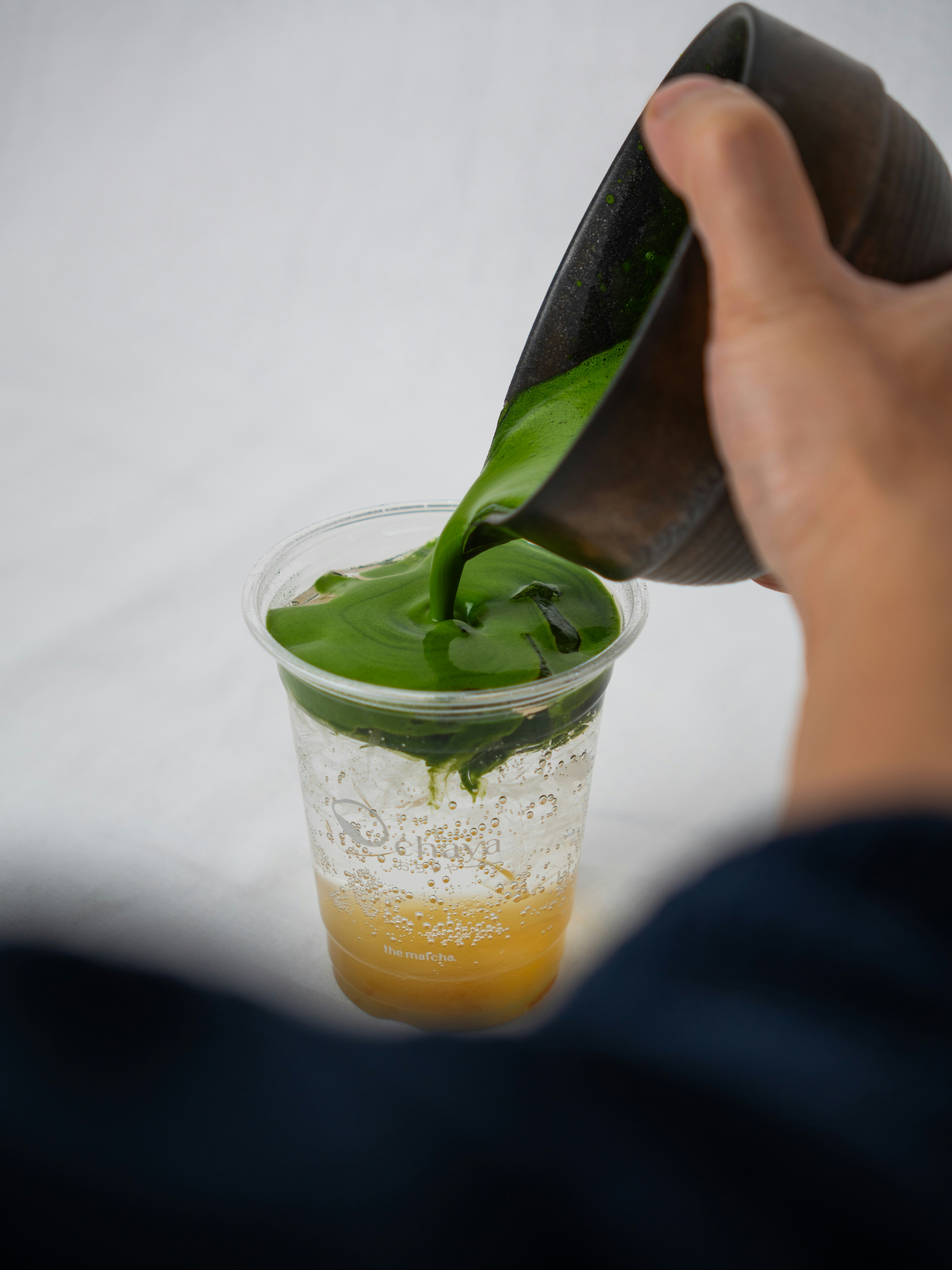 Green liquid being poured into a clear cup.