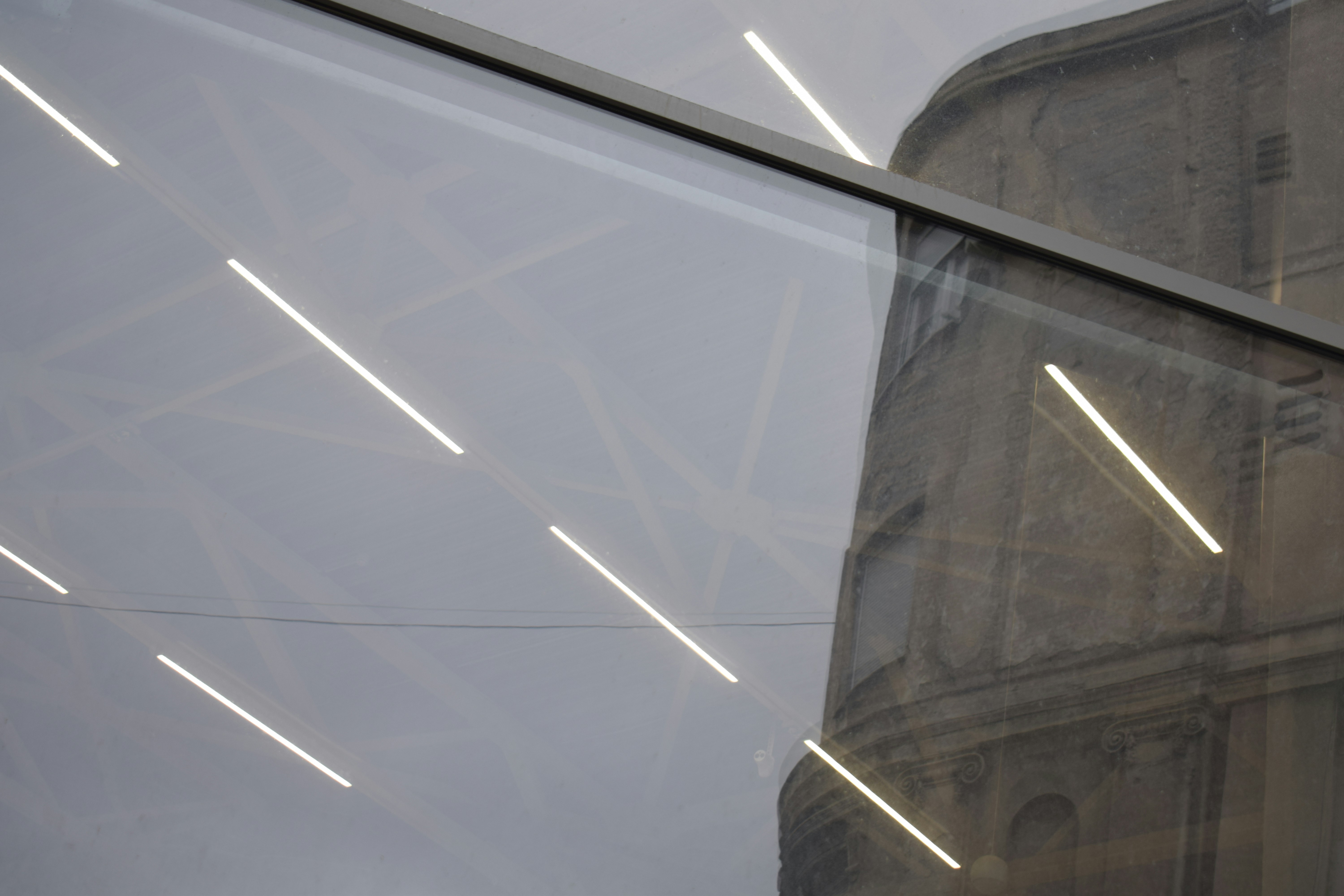 Modern lights reflect on a historic building's facade