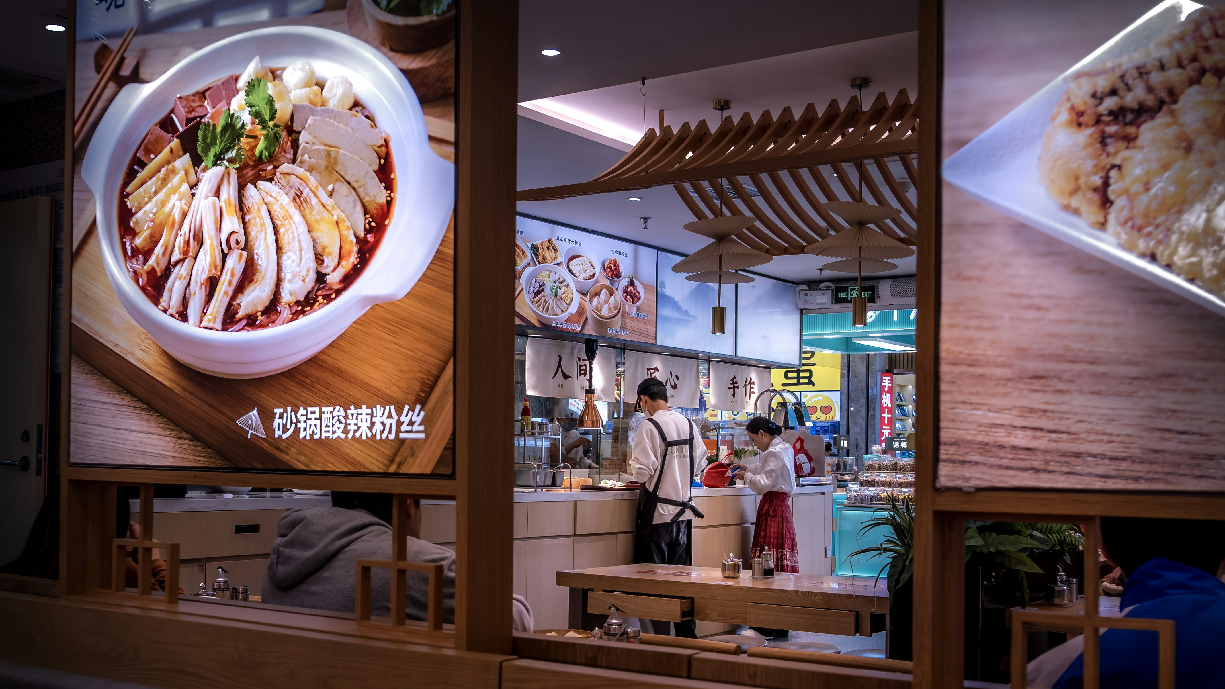 Restaurant interior with food display and staff serving staff.