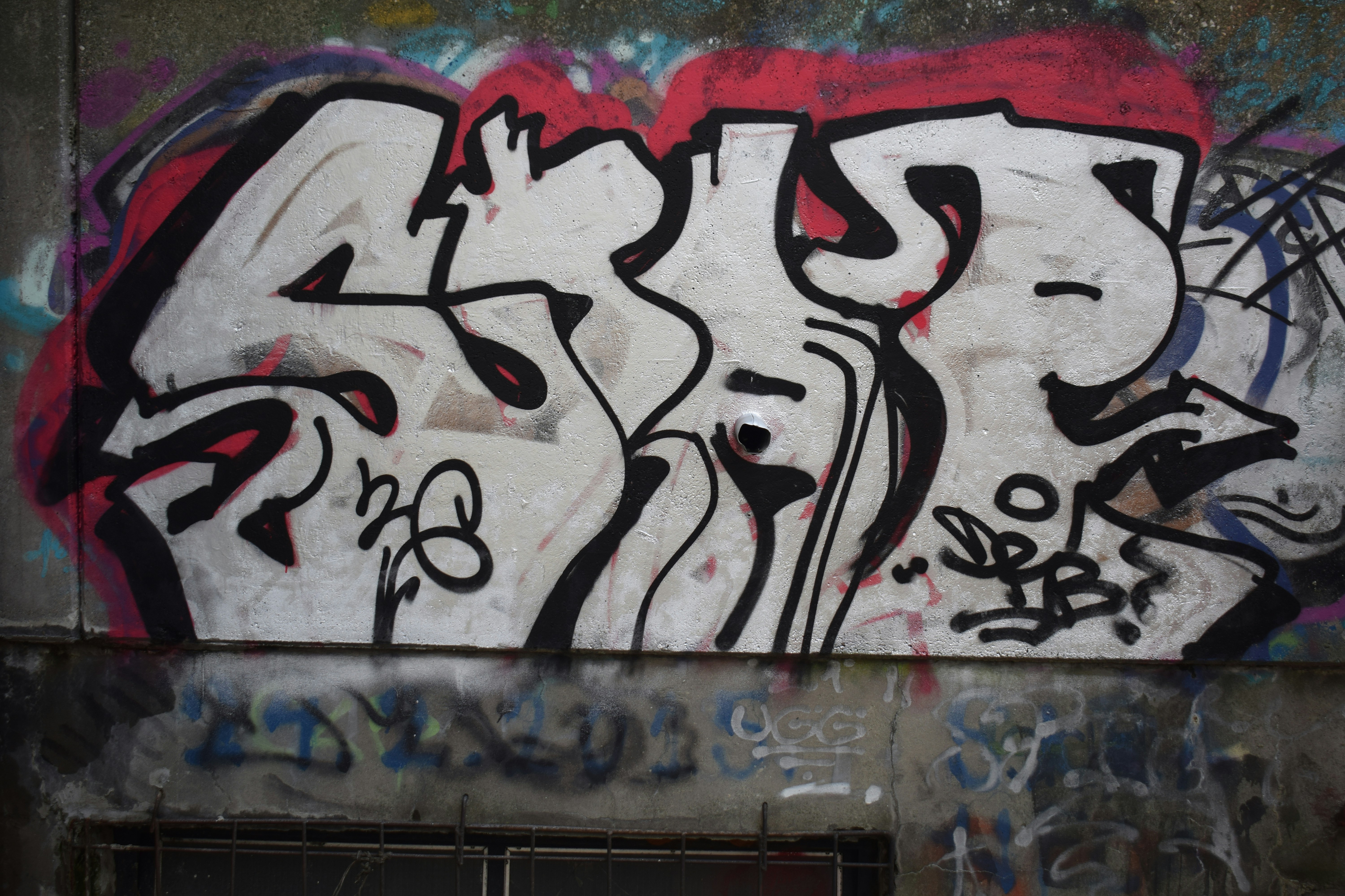 Graffiti art on a concrete wall with red accents