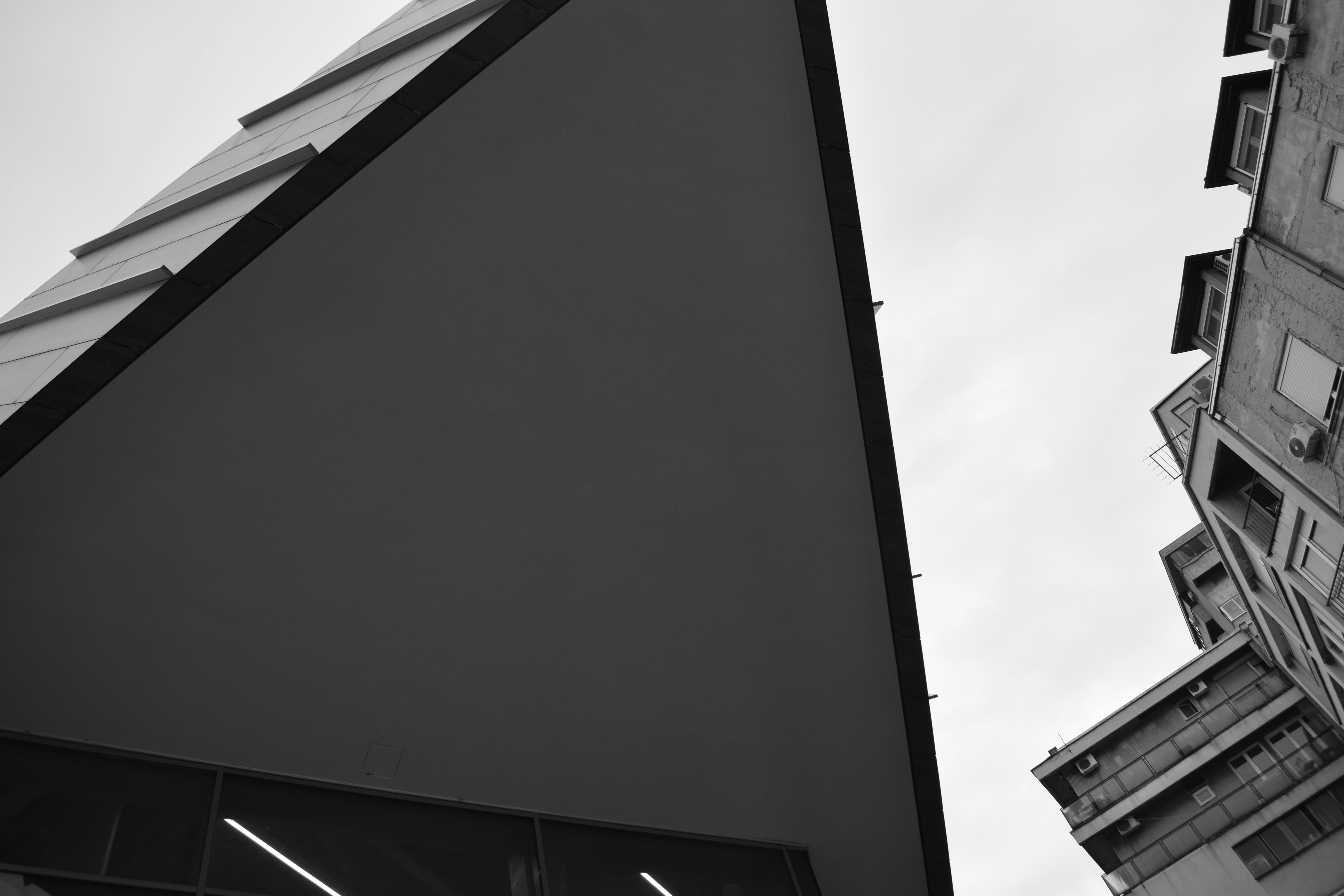 Modern triangular building facade against sky