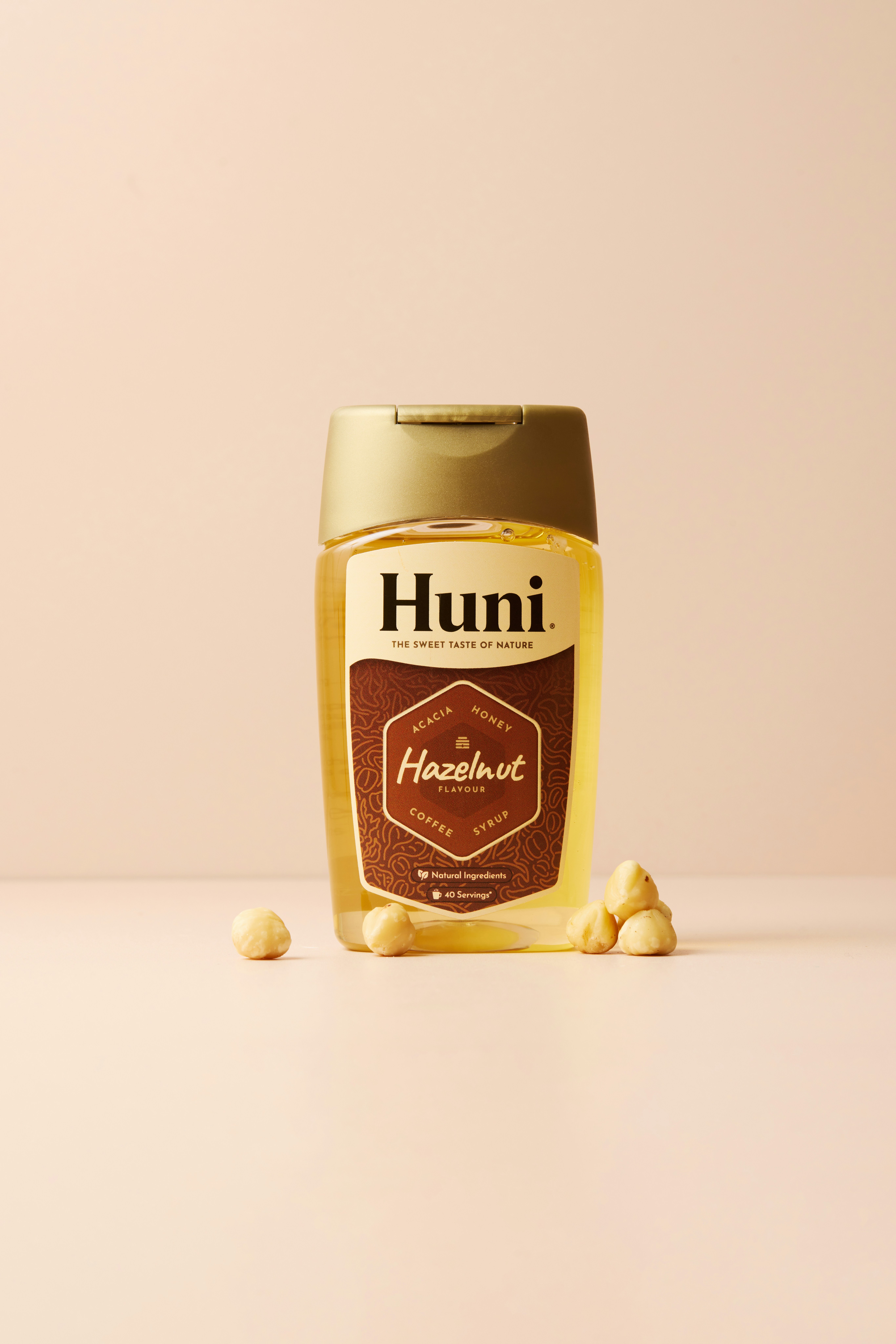 Bottle of huni hazelnut syrup with hazelnuts