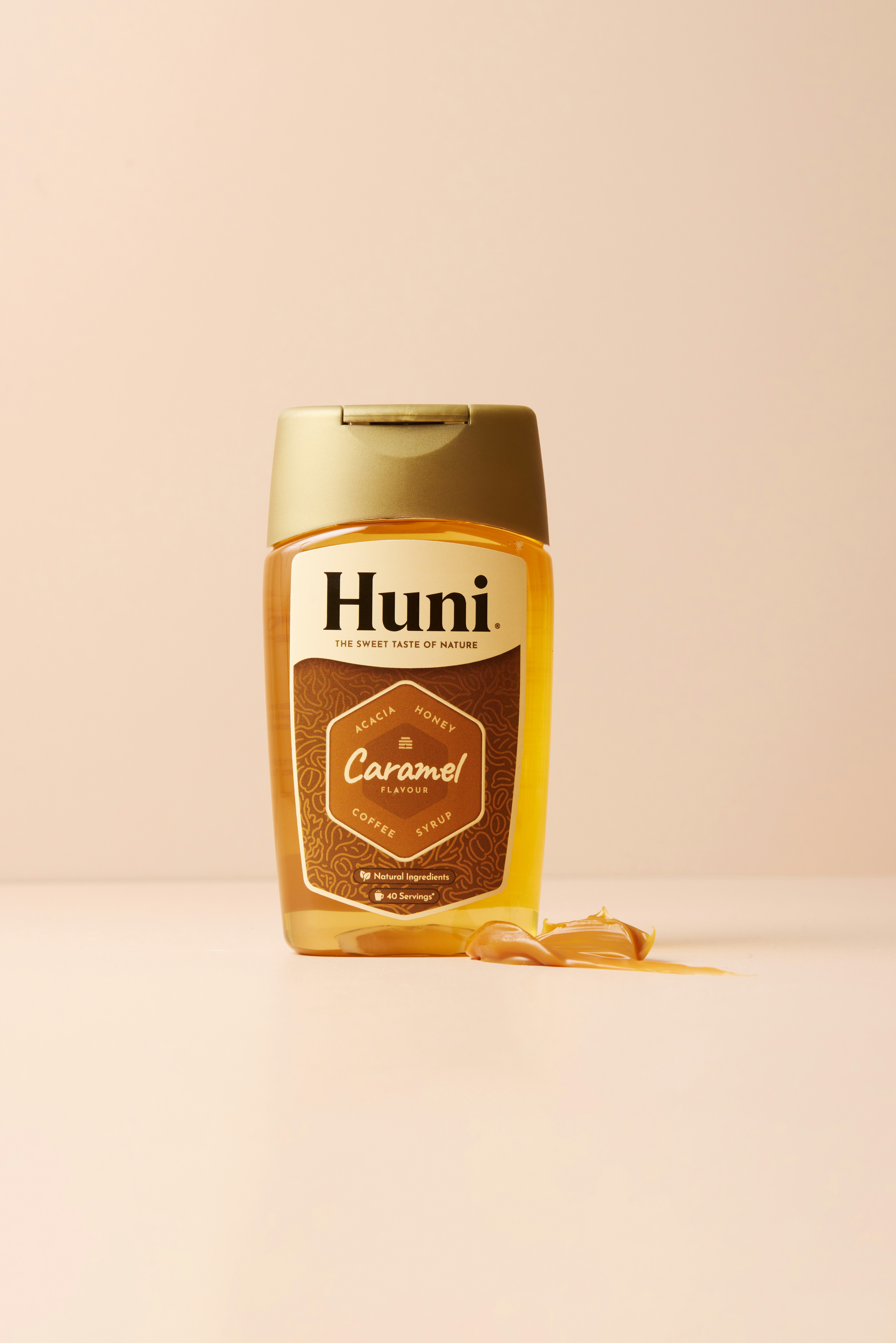 A bottle of huni caramel syrup with syrup spilled out