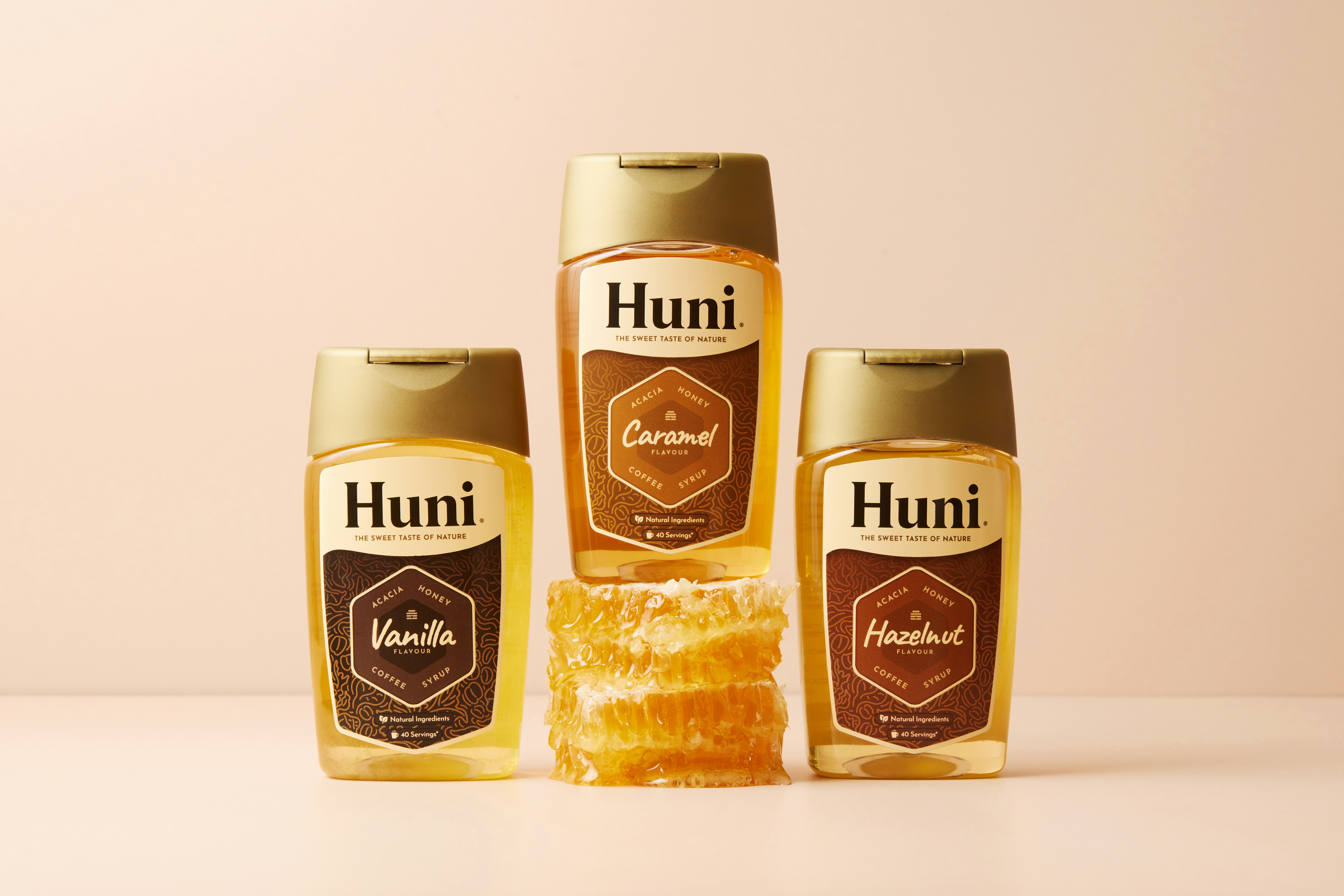 Three huni honey bottles with honeycomb