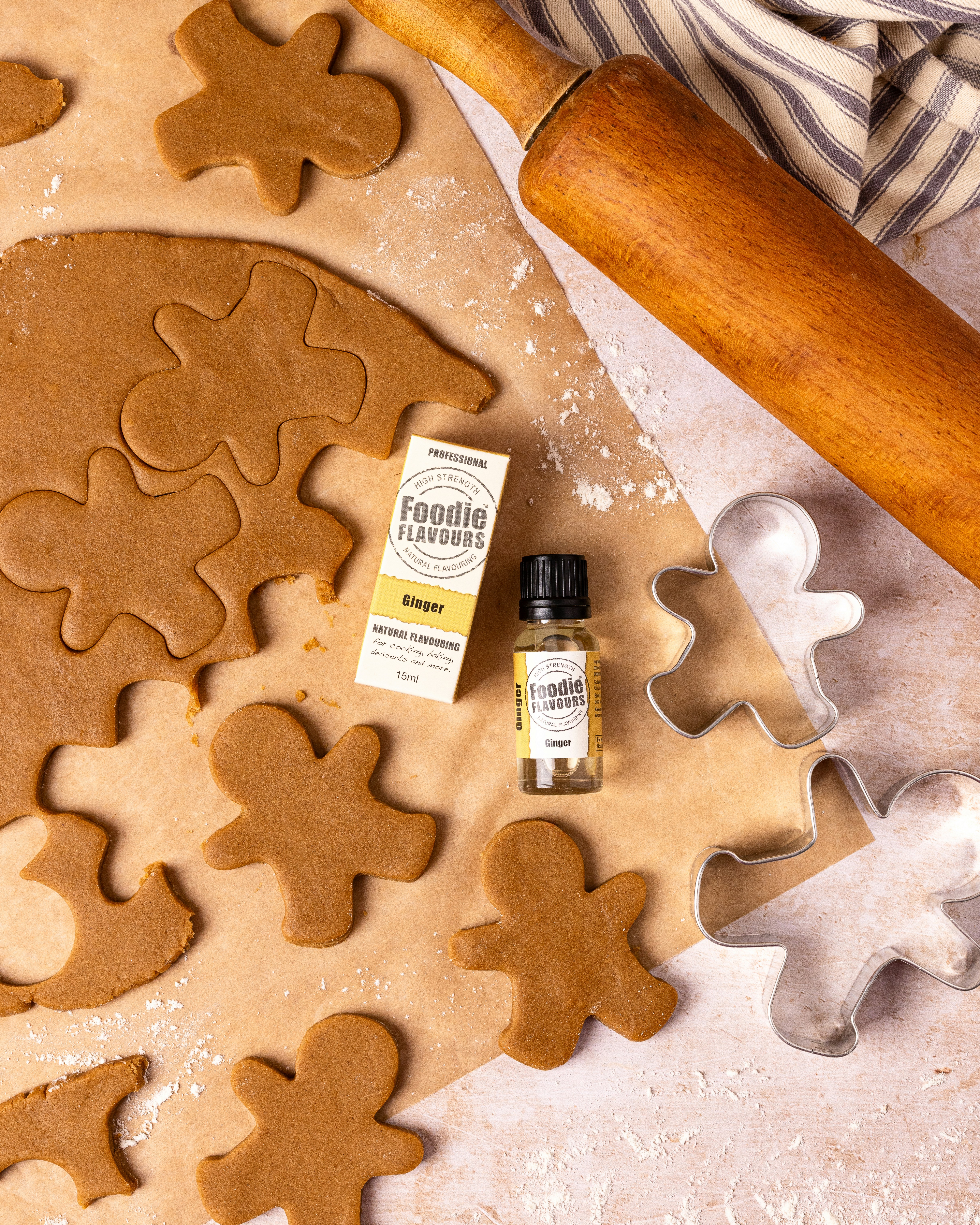 Gingerbread dough cut into festive shapes with rolling pin.