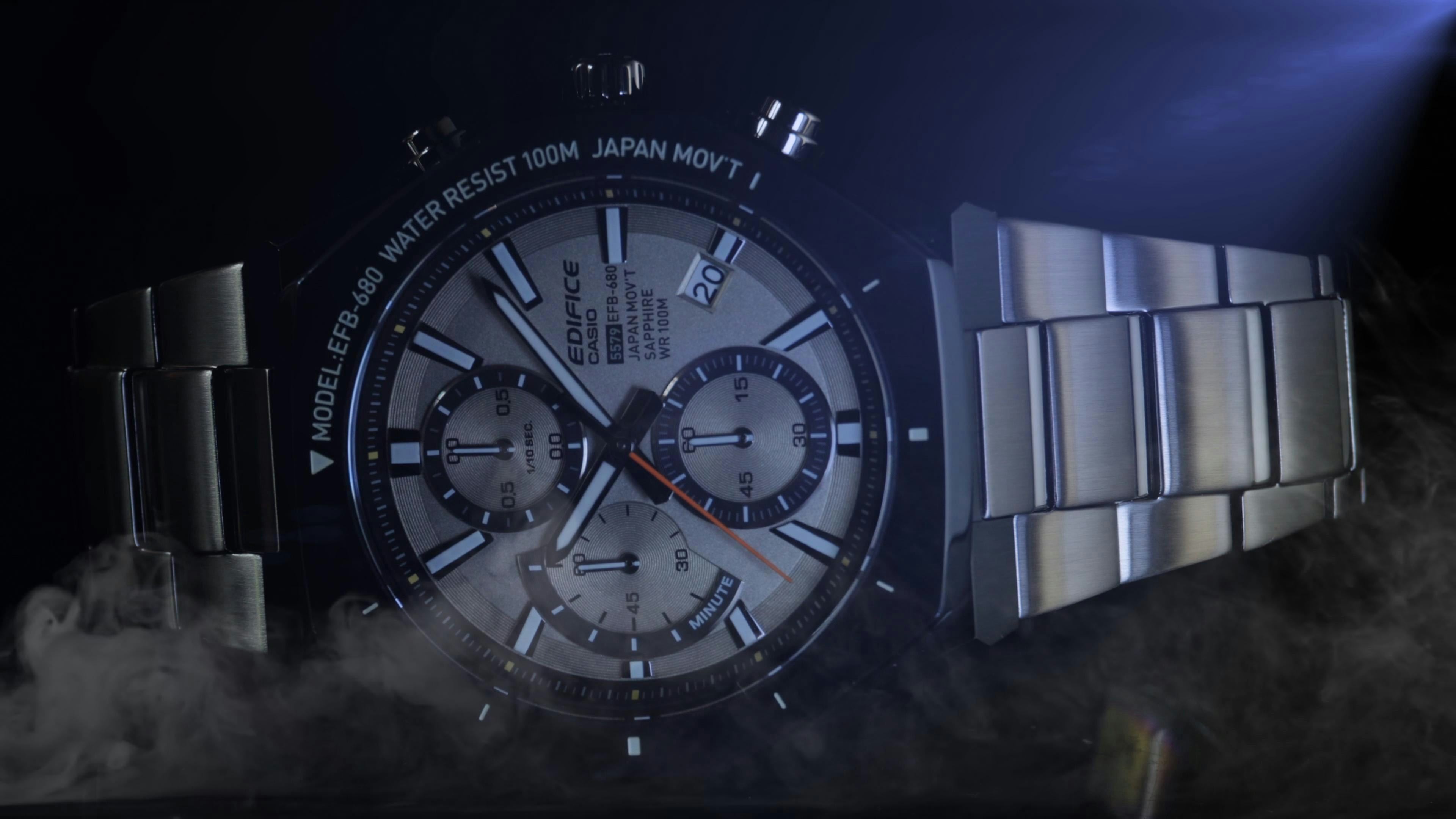 A detailed close-up of a silver chronograph watch