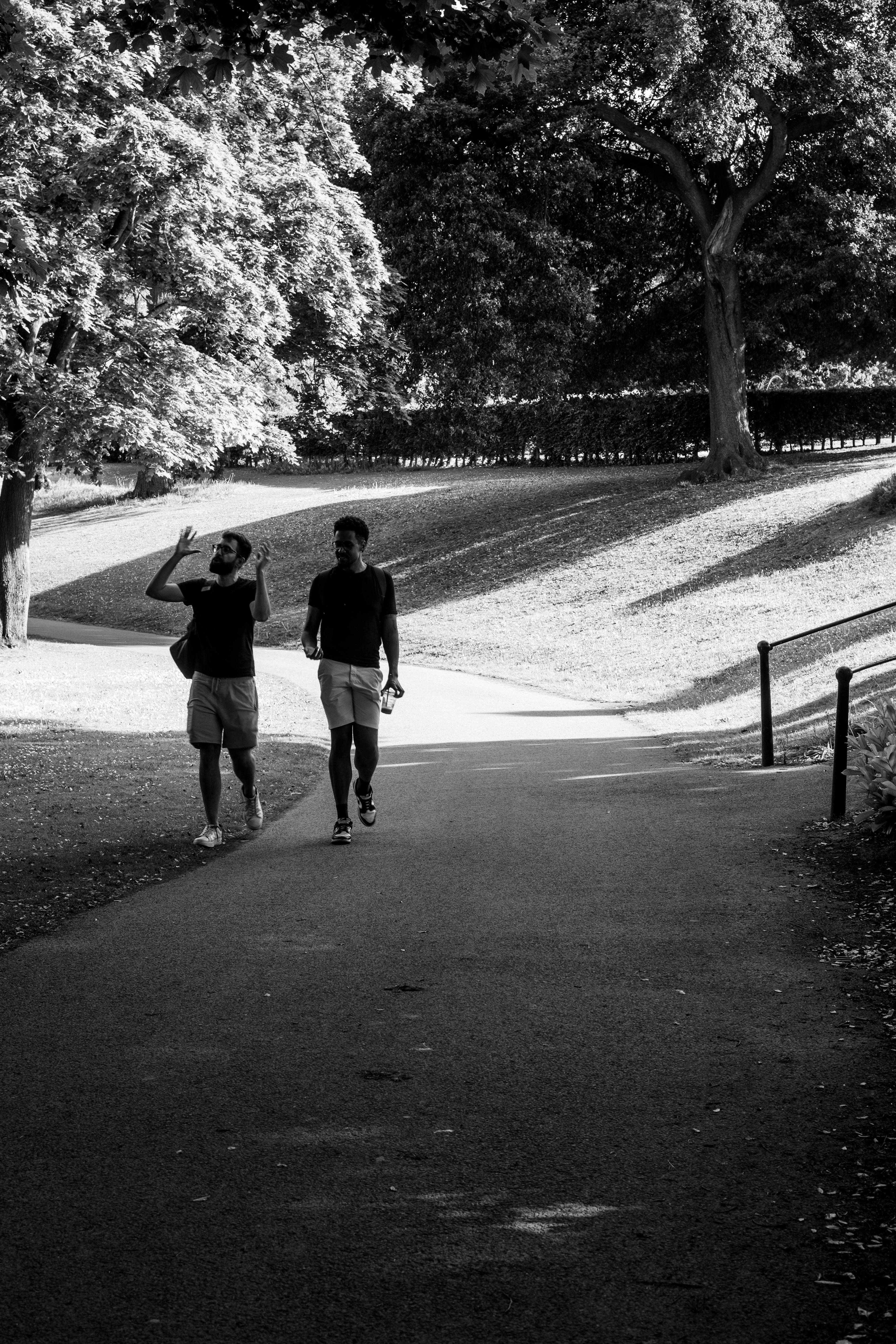 Two men walking on a park path