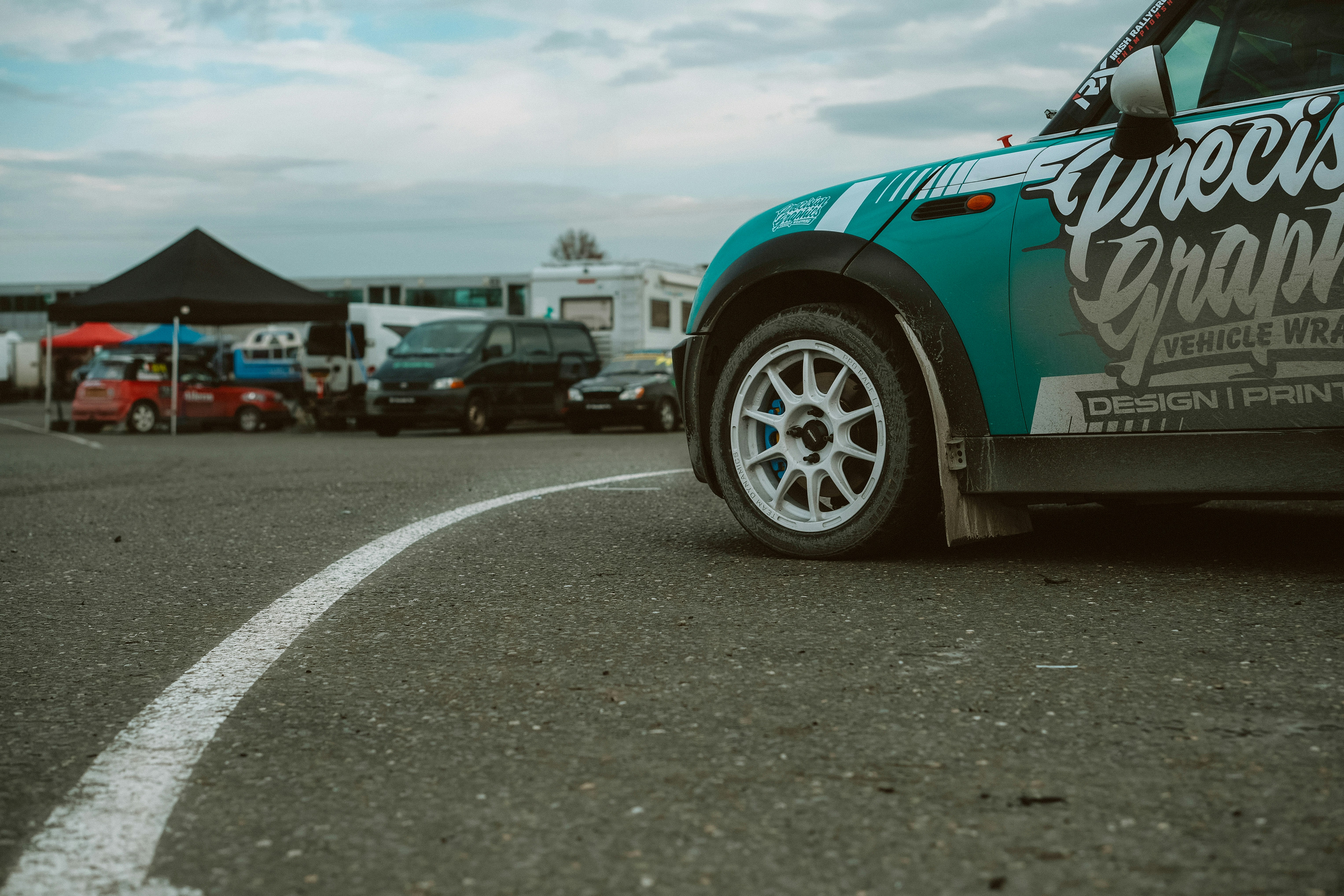 A teal and white car on a racetrack.