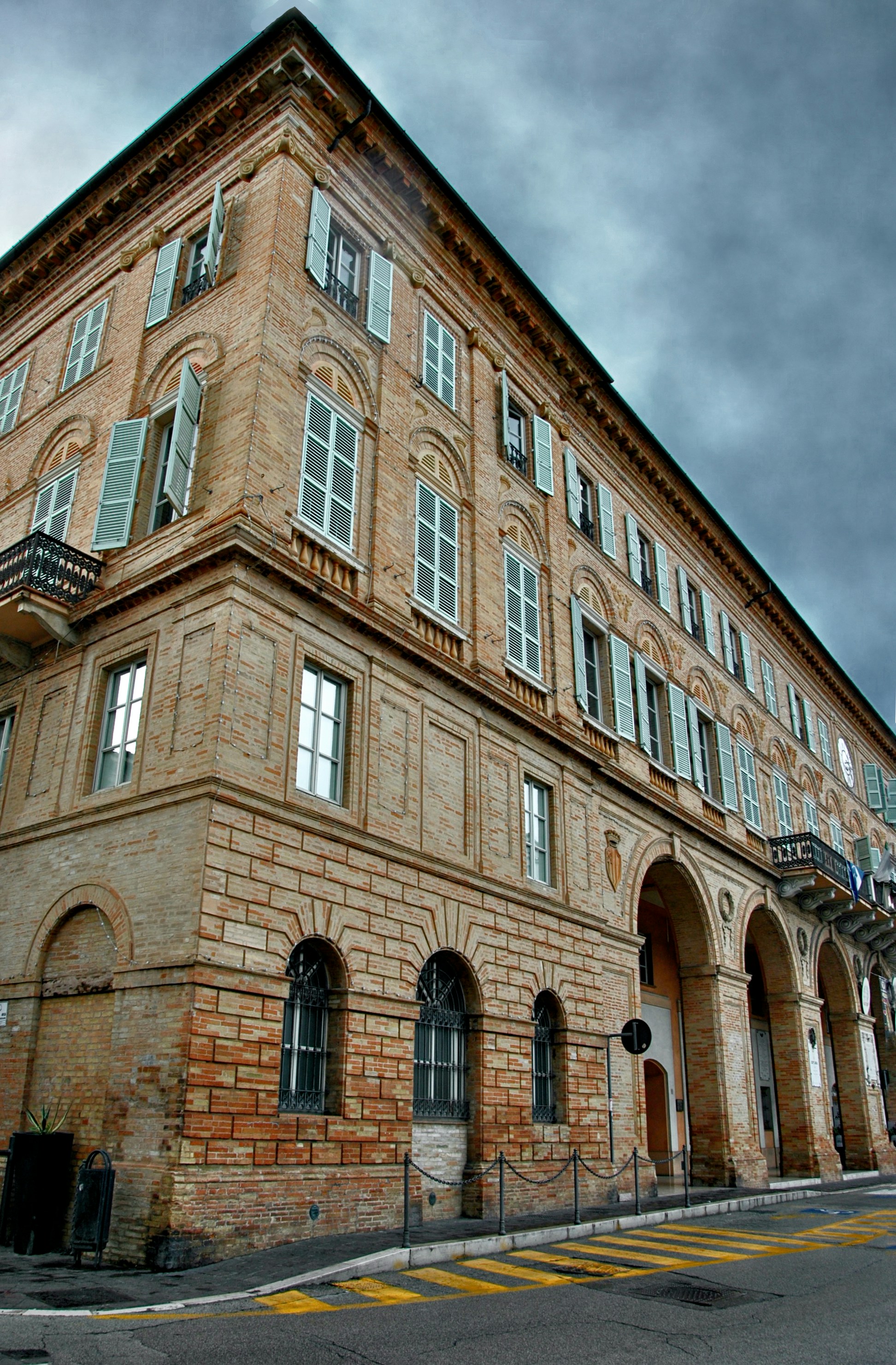 A large brick building with many windows and shutters.