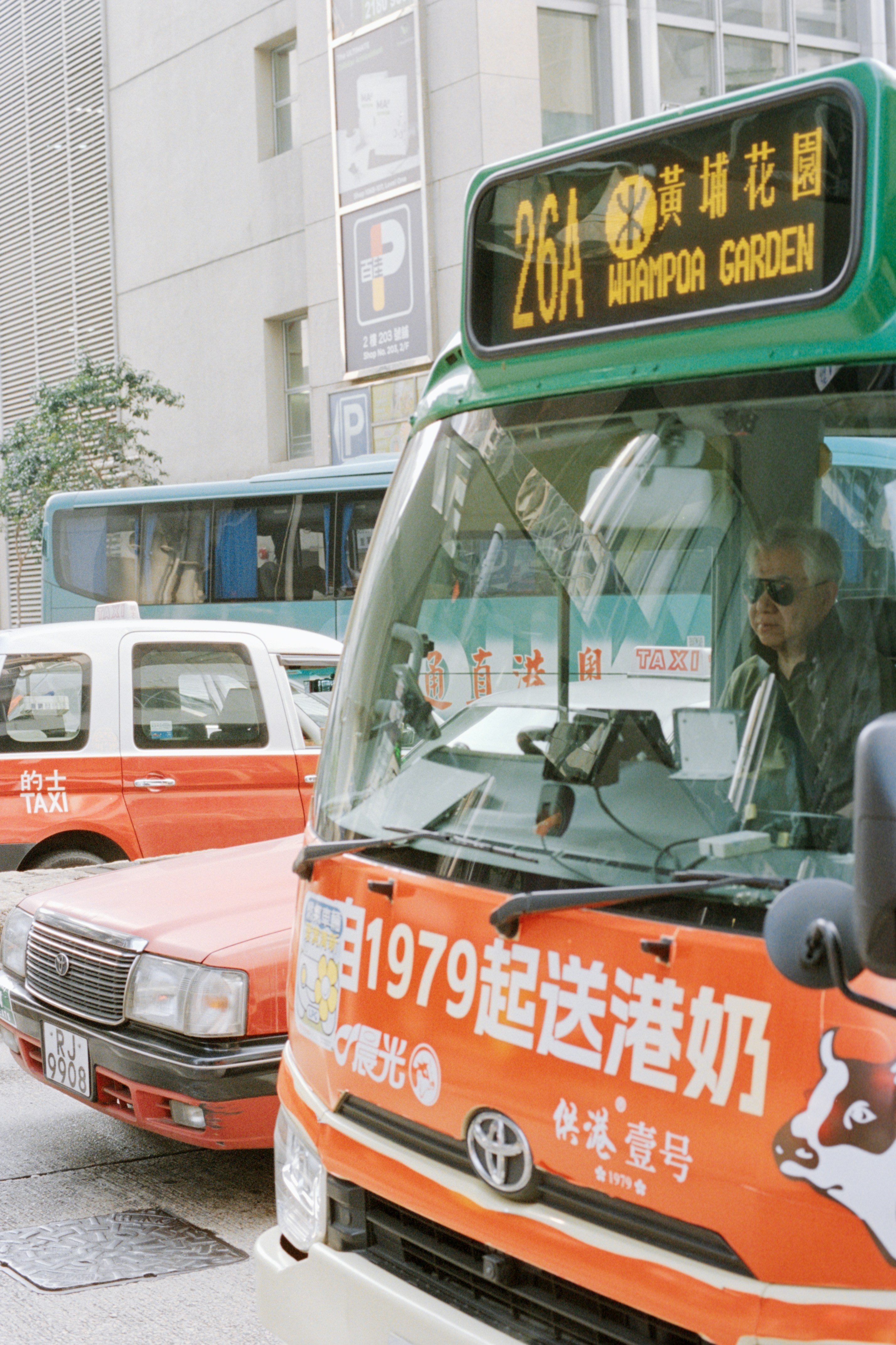 Bus driver behind the wheel in a city street.