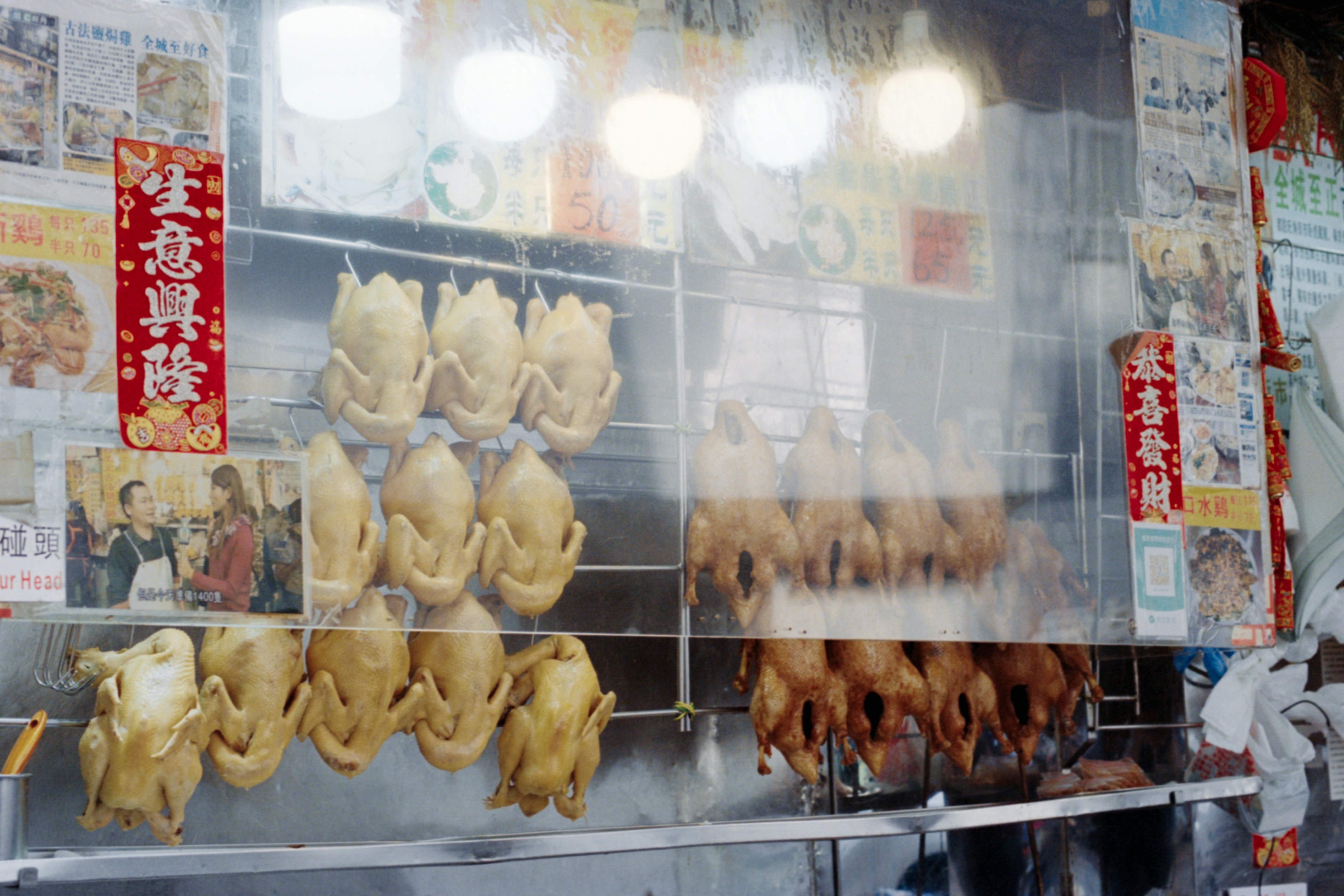 Roast chickens hanging in a market stall.