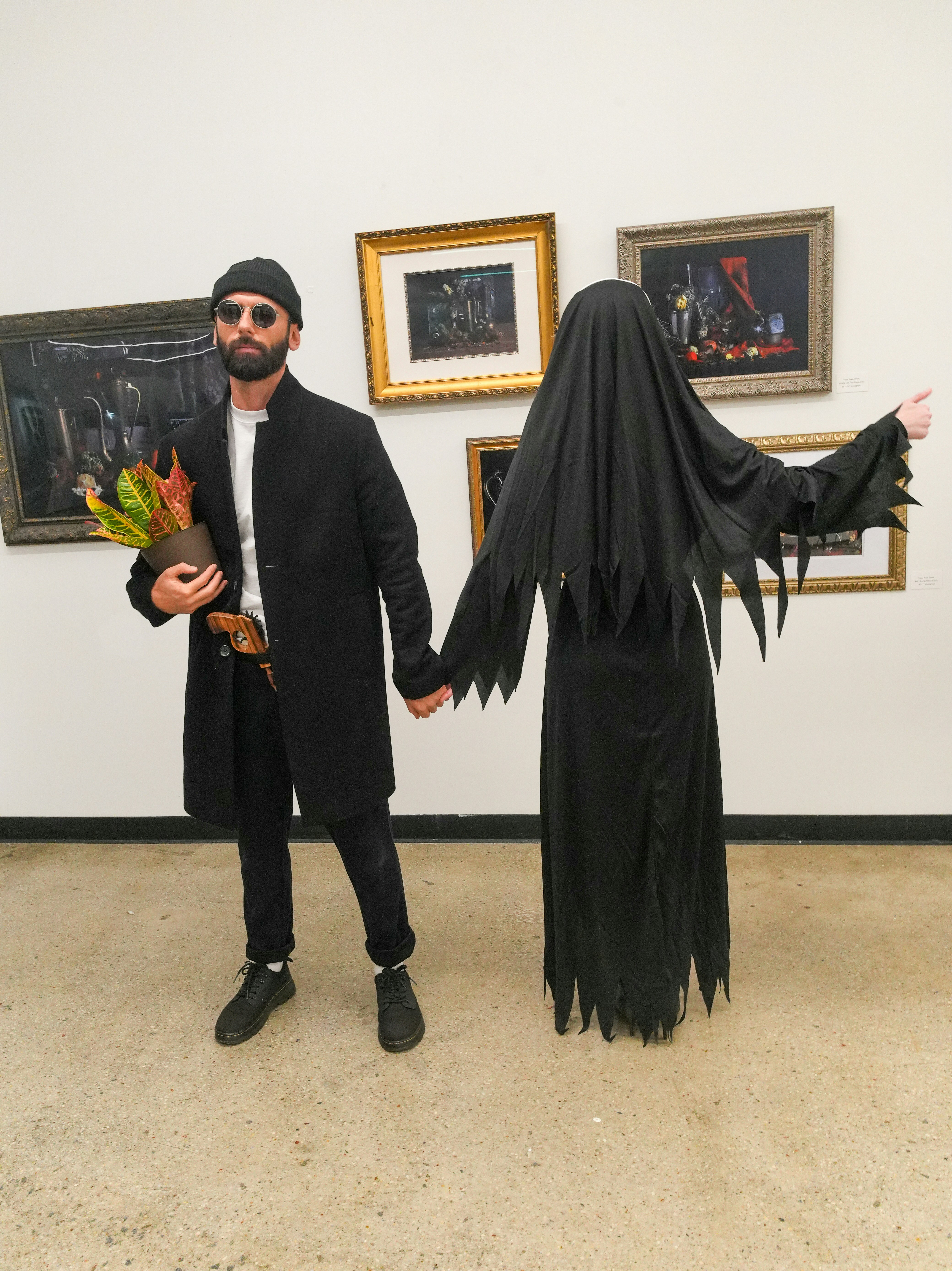 Man in black holding plant, ghost beside him
