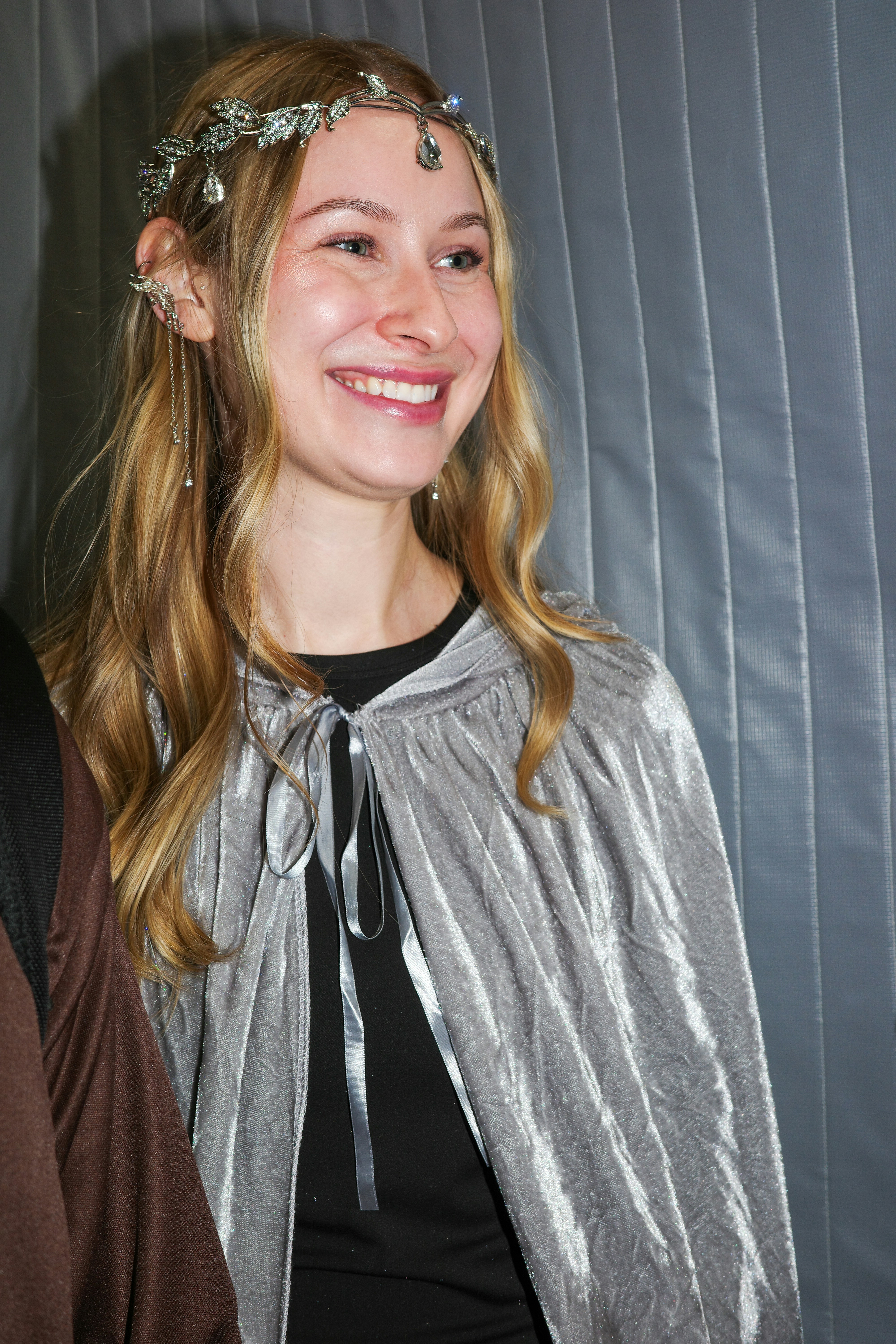 Young woman wearing a silver cape and elven crown
