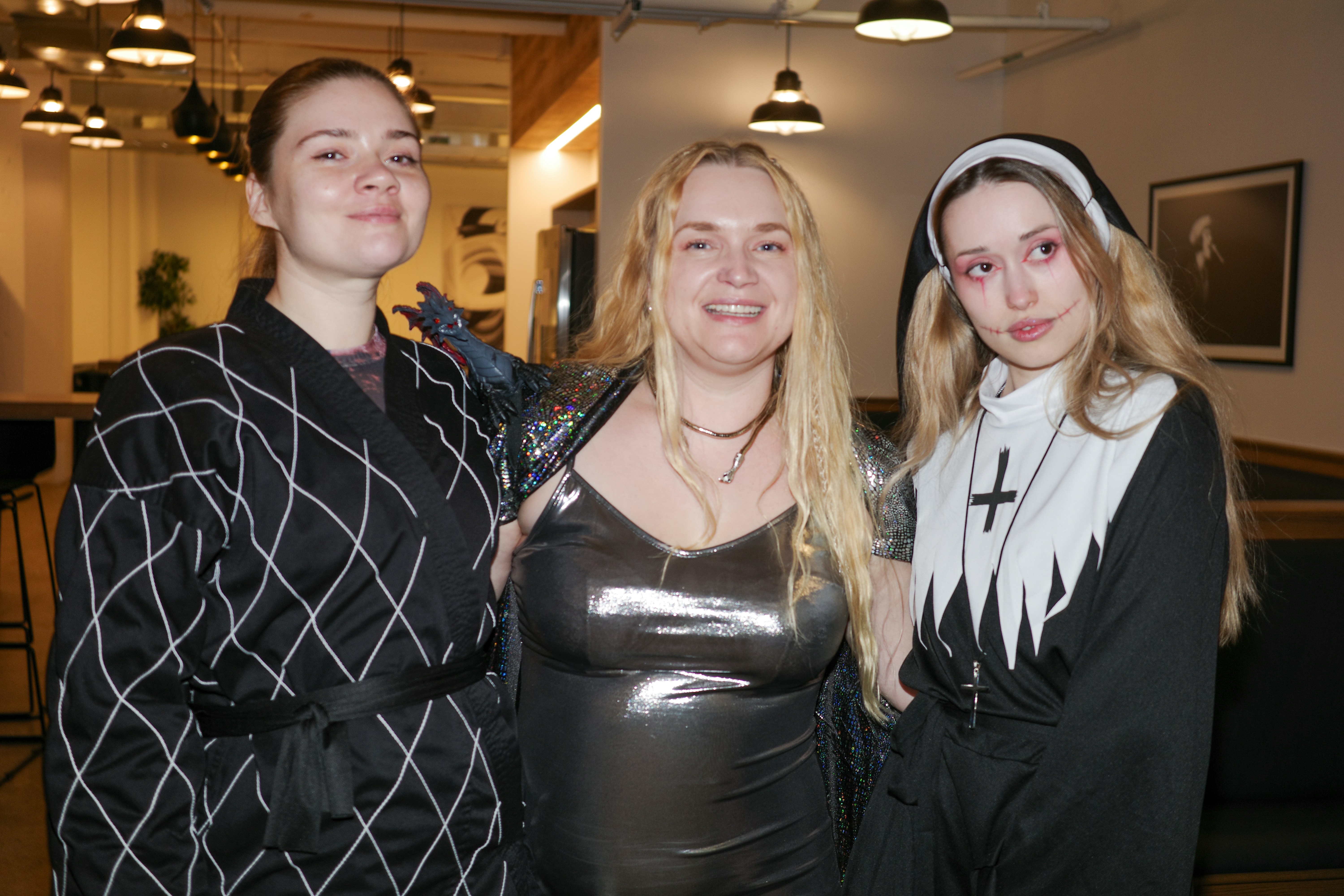 Three women in costumes posing for a picture.