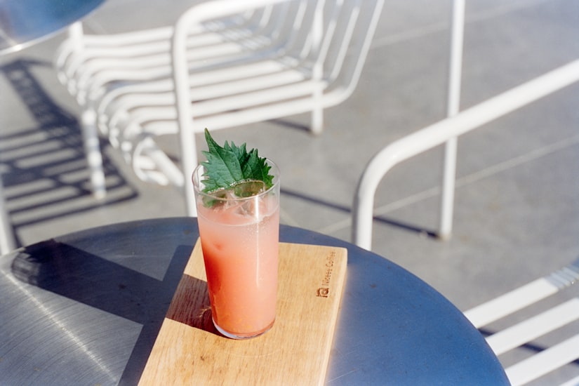 Cocktail rose garni d'une feuille sur une terrasse