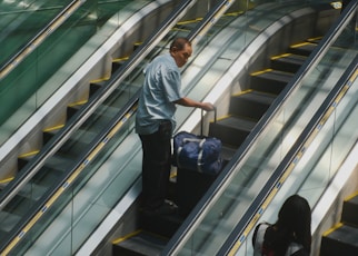 Man with luggage on an escalator