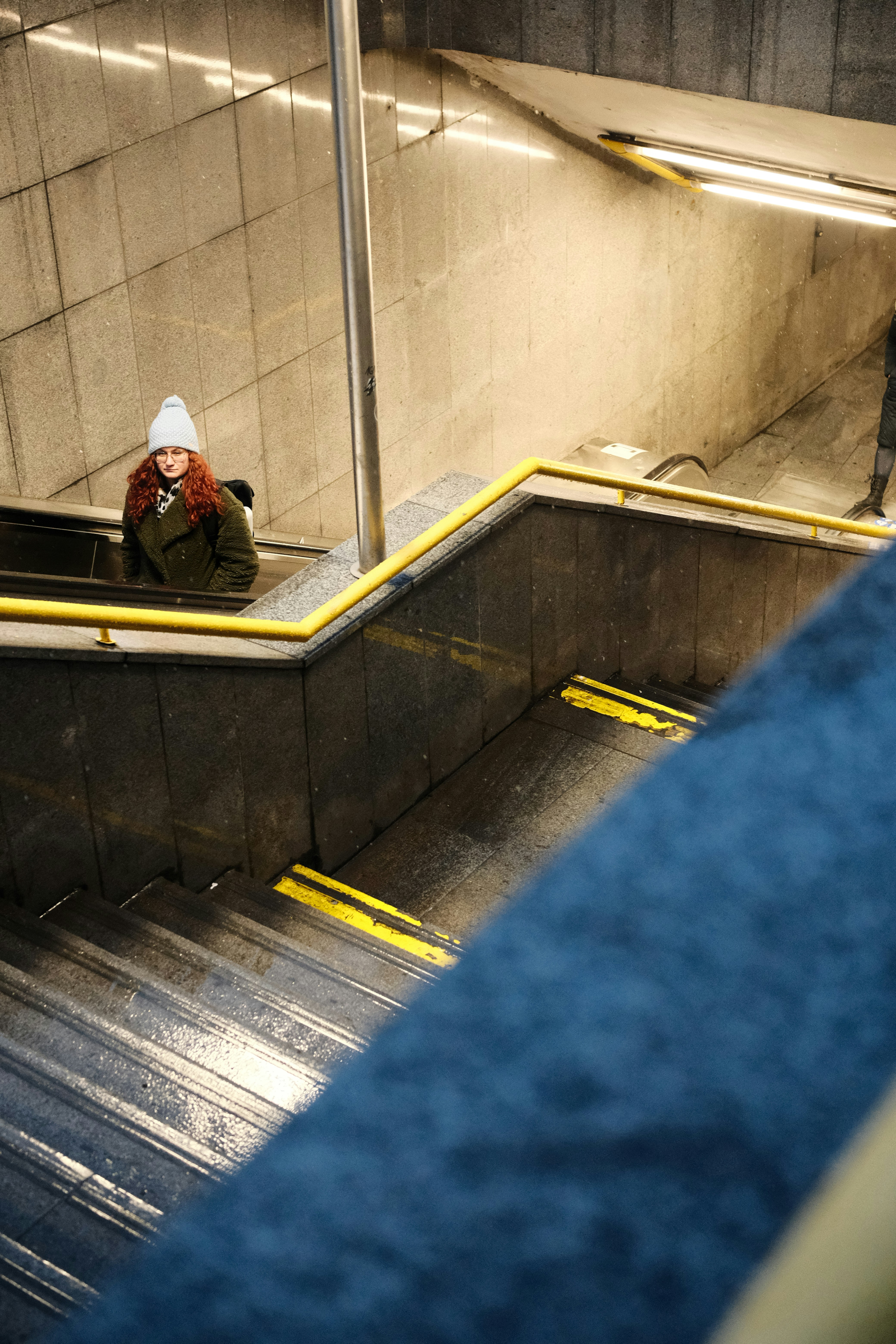 Frau auf einer Rolltreppe in einer U-Bahn-Station