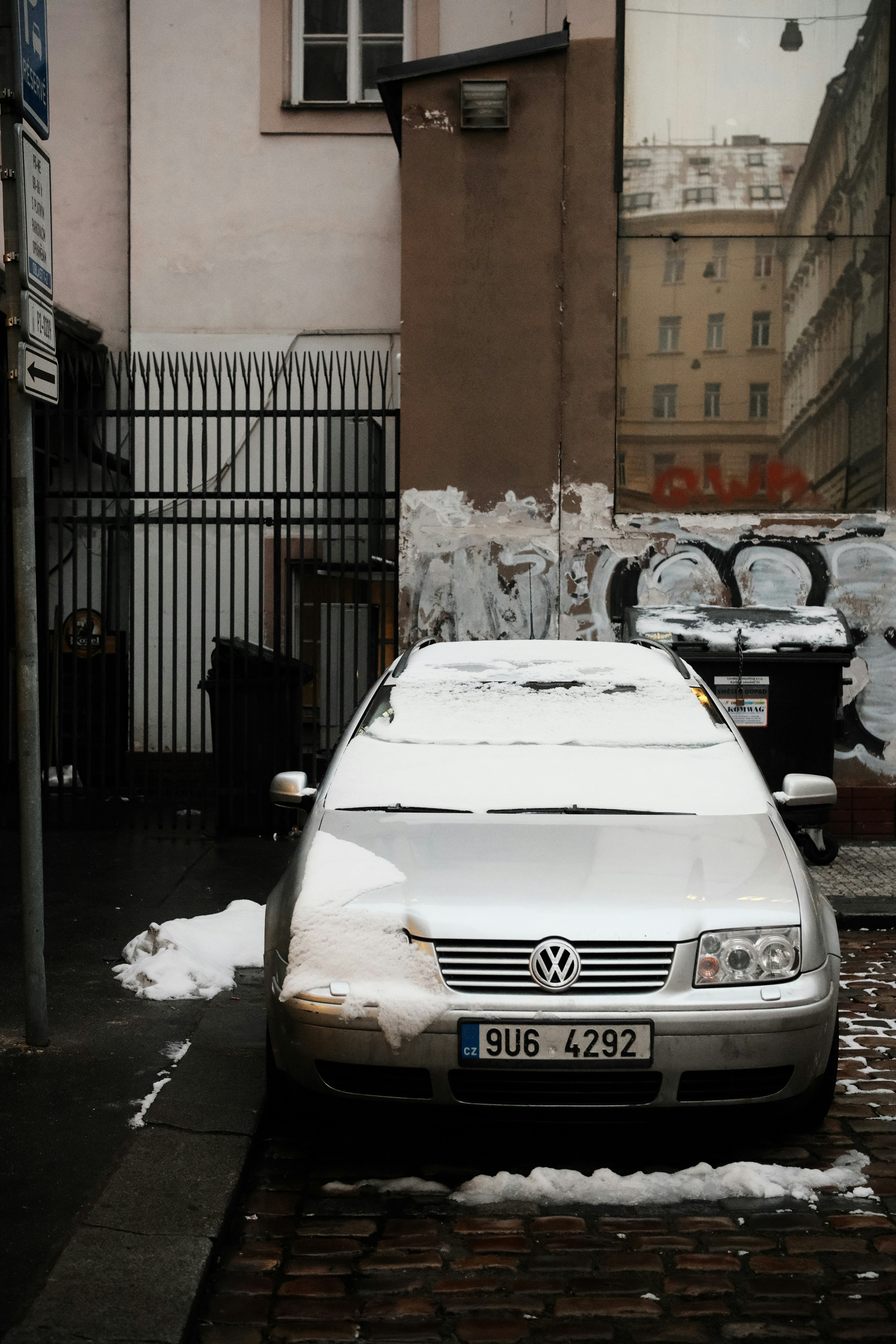 Silbernes Auto bedeckt mit Schnee auf einer Straße.