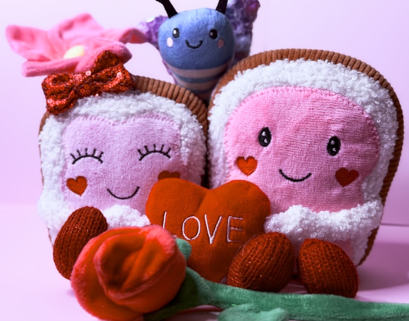 Two plush toast characters with a heart and rose.