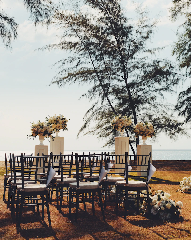 Wedding ceremony setup on a grassy area near the ocean.