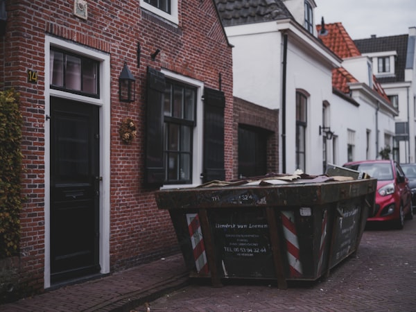 Roll-off dumpster on a residential street — Haberdoedas on Unsplash