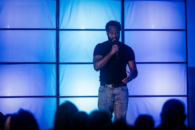 A man speaking into a microphone on a stage.