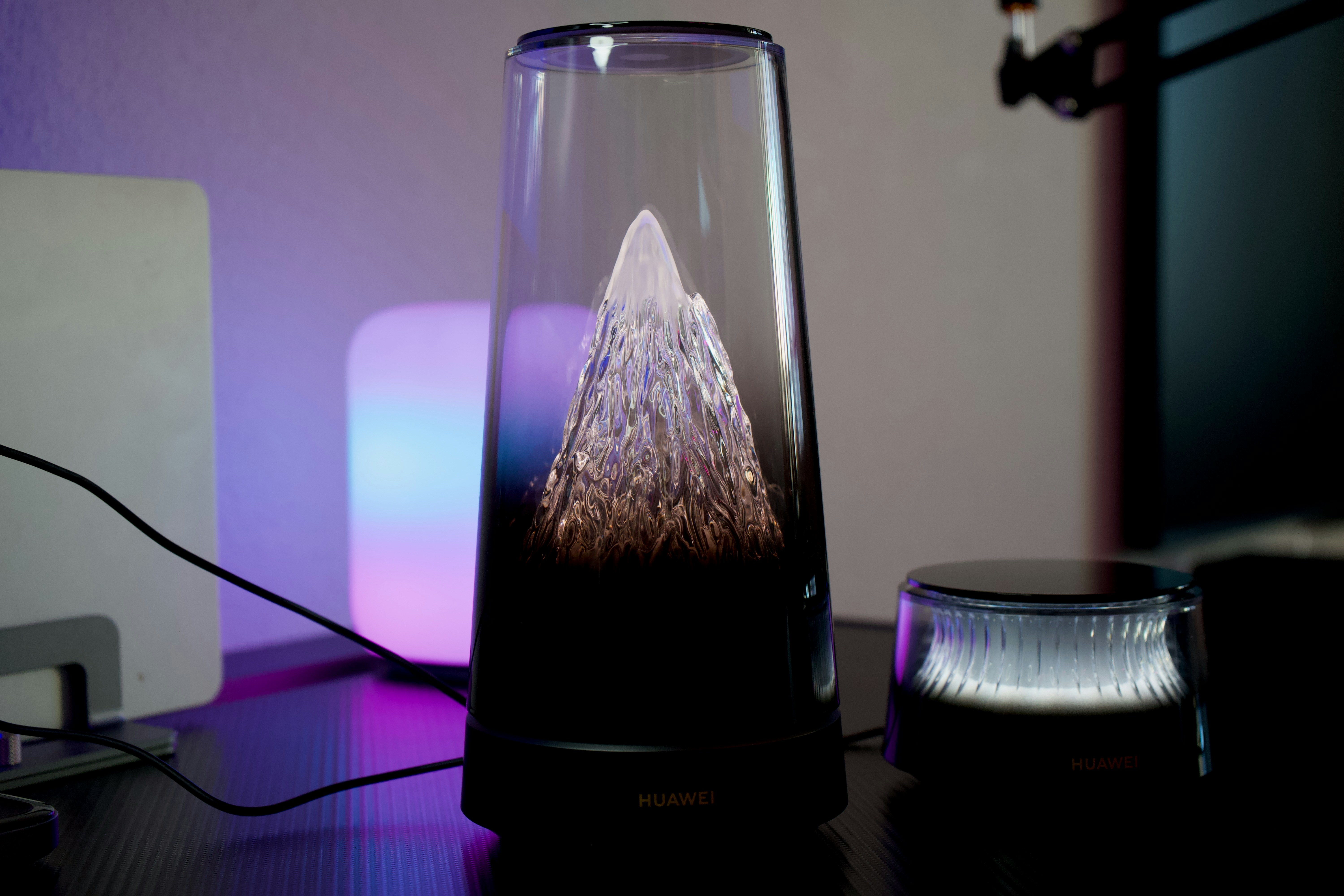A glass lamp with a mountain inside on a desk
