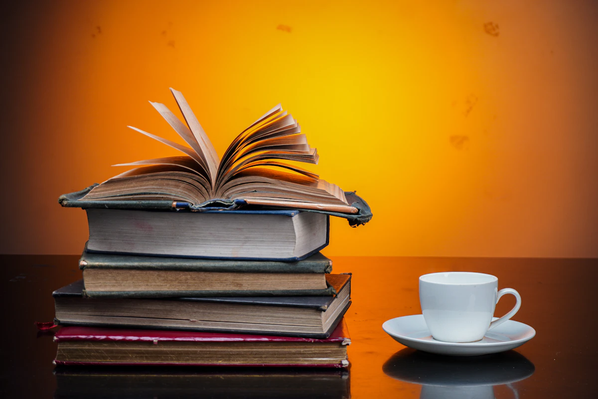 A cozy stack of books beside a warm cup of coffee
