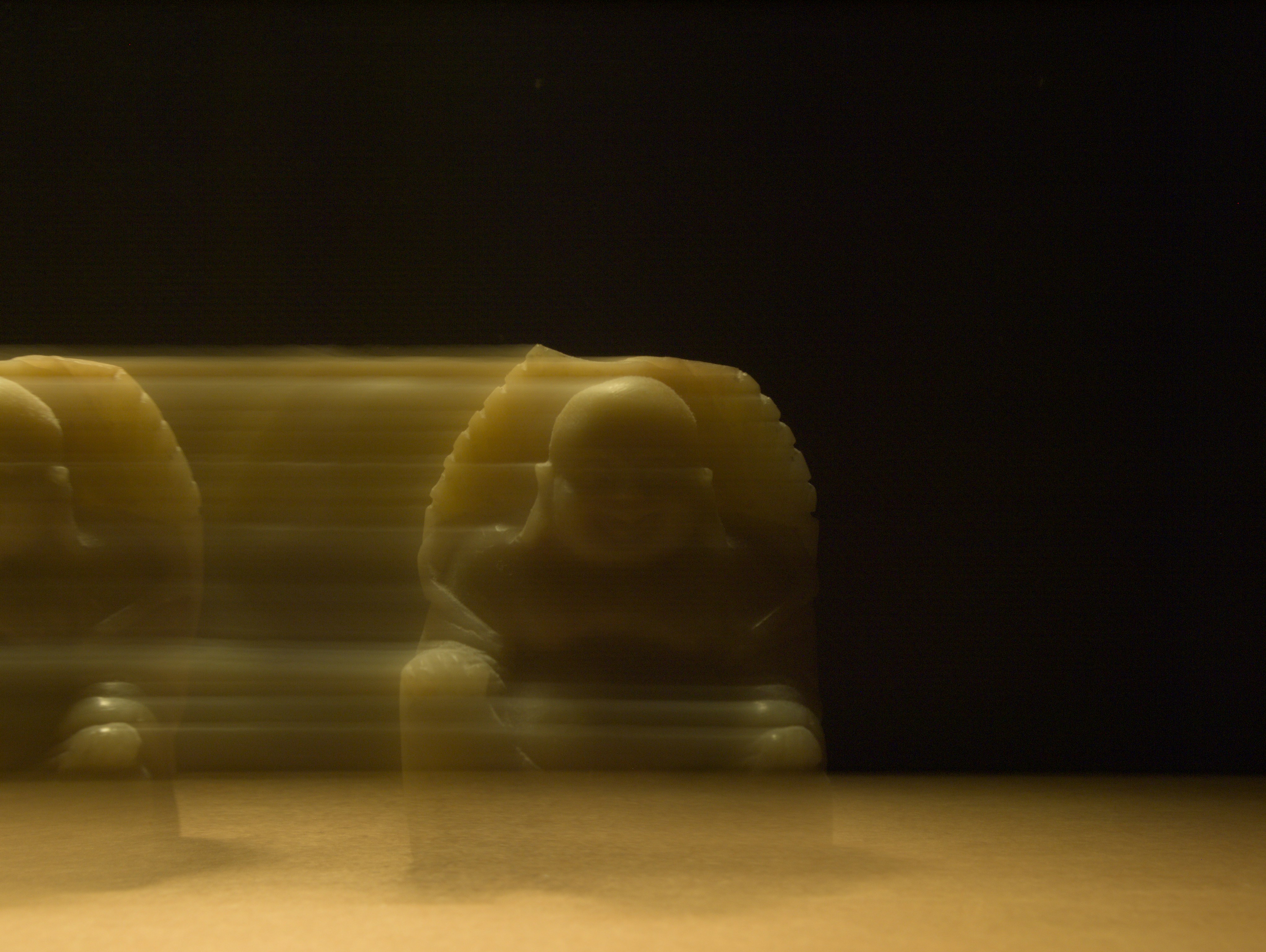 Two blurred figures sitting on a surface