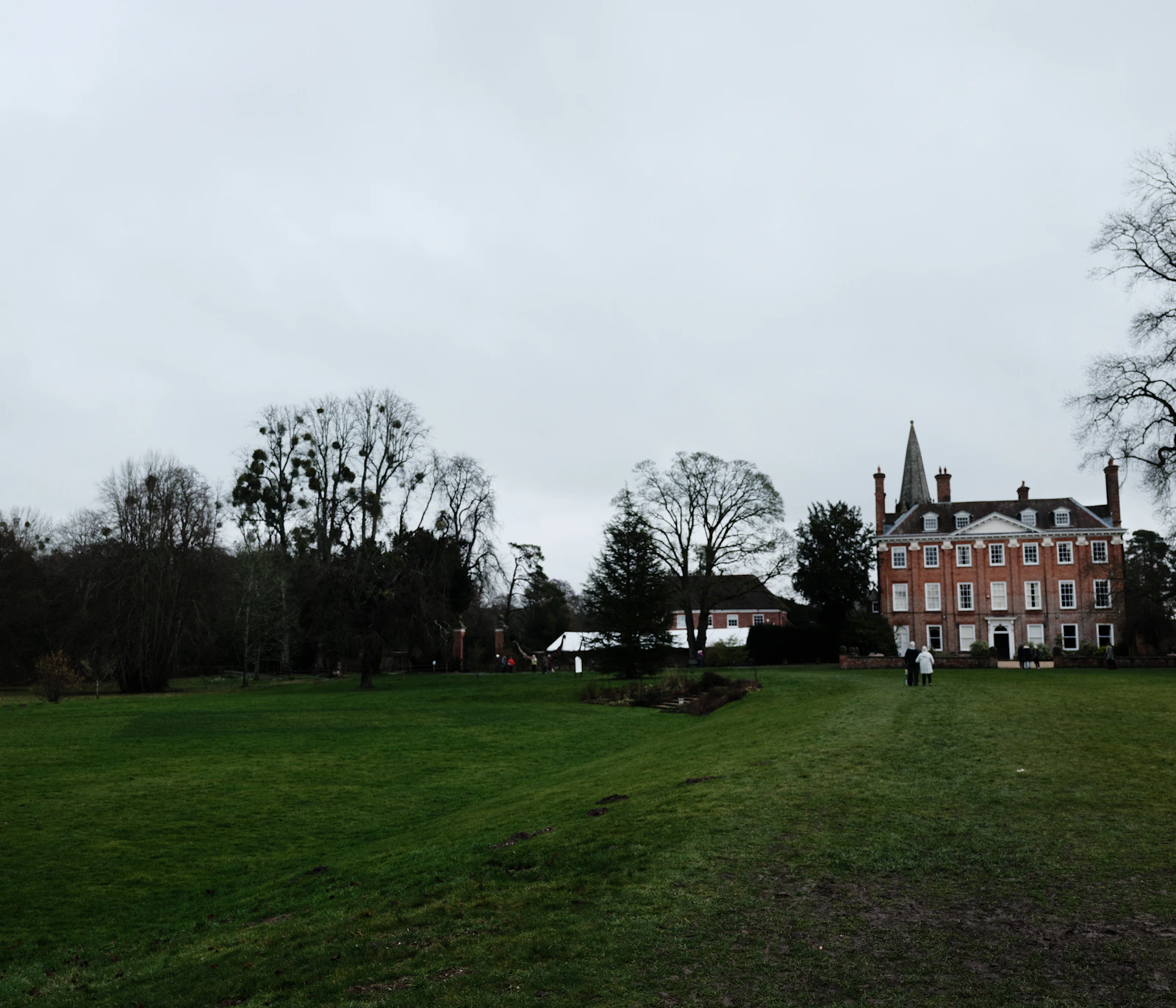 Illustrative country house surrounded by gardens and mature trees
