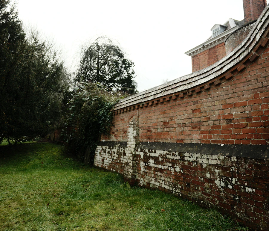 Curved old brick garden wall running alongside a lawn