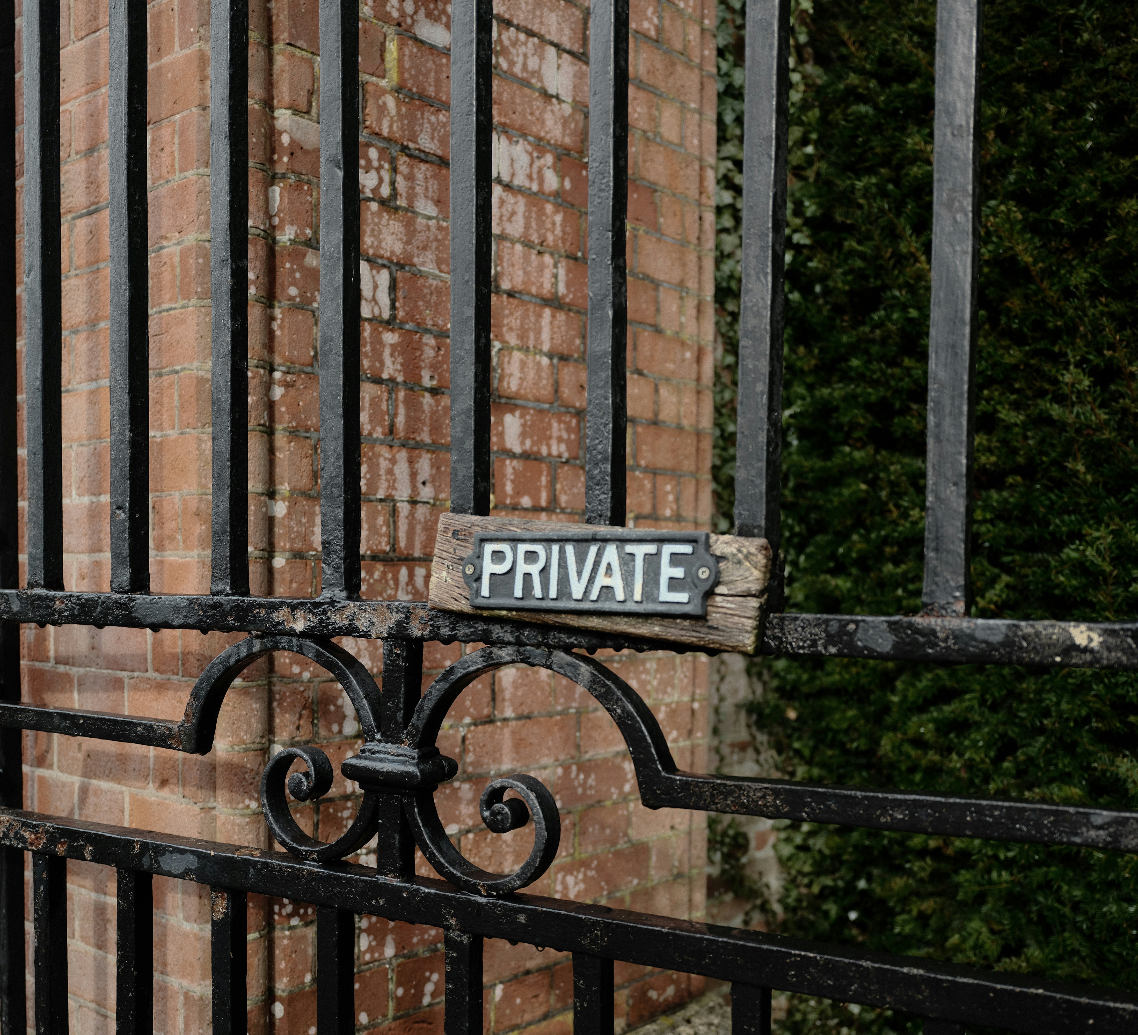 Ein verwittertes "Privat"-Schild an einem Metalltor.