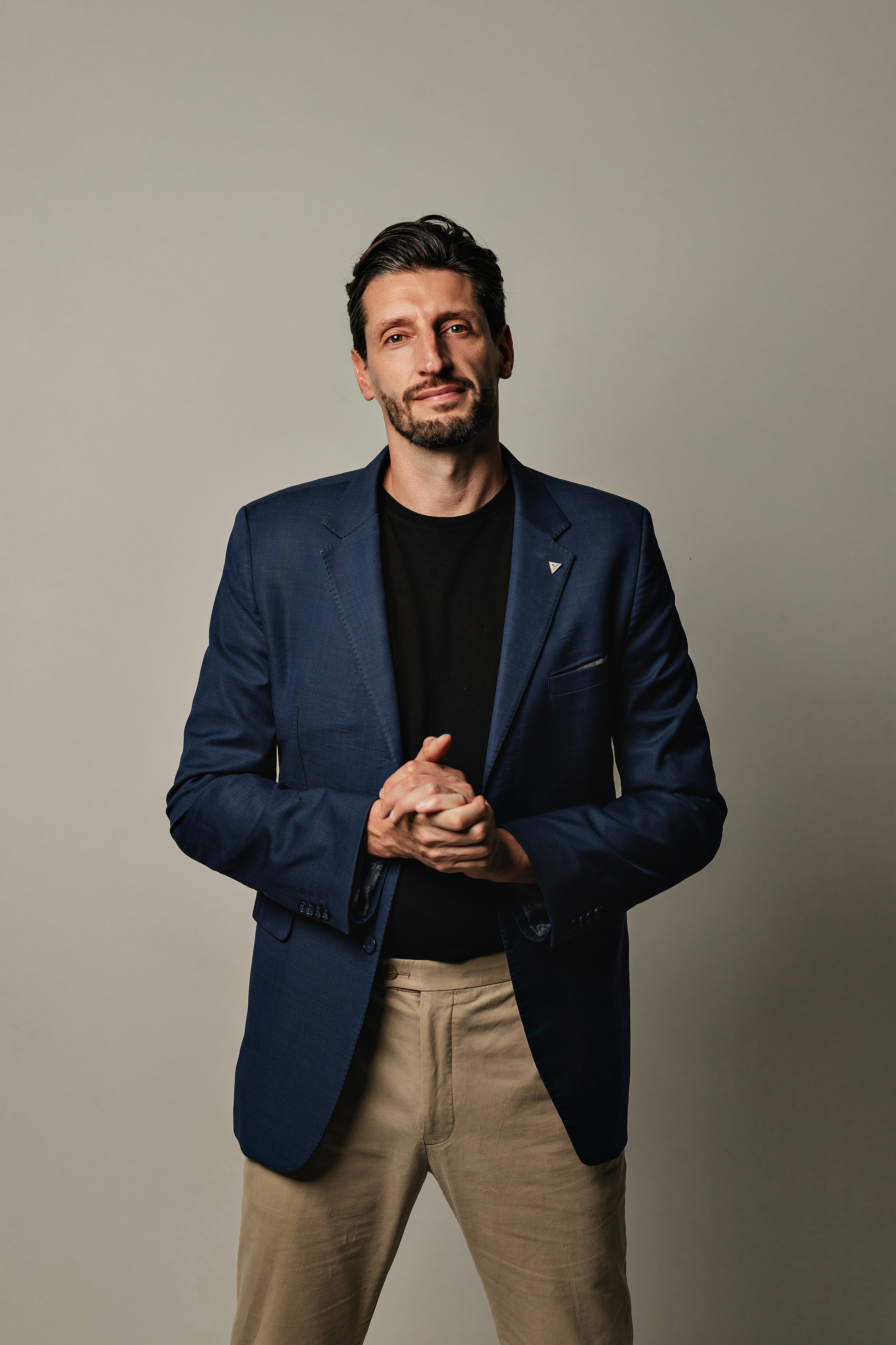 Mann in blauem Blazer und beigefarbener Hose