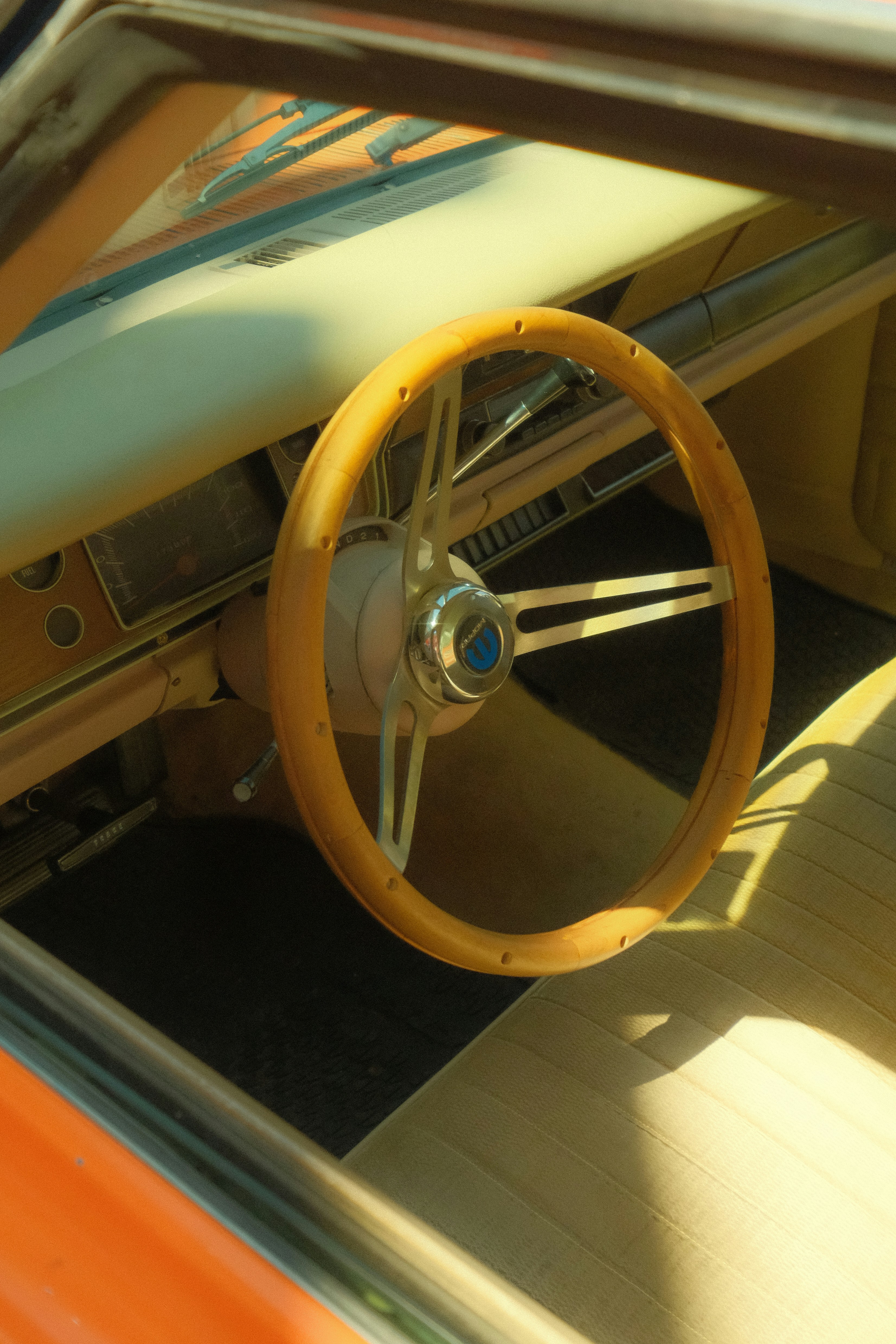 Close-up of a vintage car's wooden steering wheel.