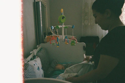 Mother tucking in her baby in a crib