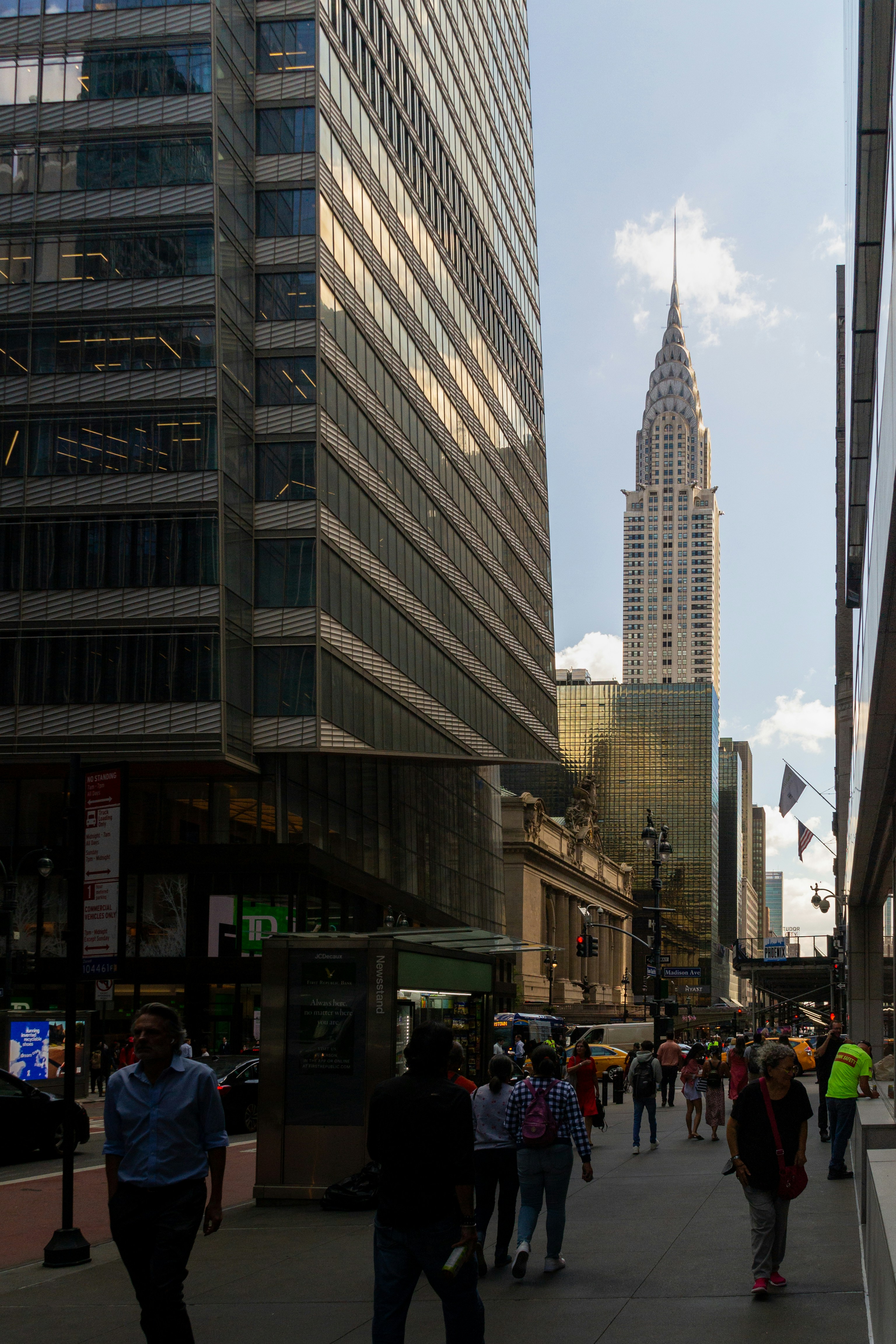 Persone che camminano per una strada cittadina con edifici alti.