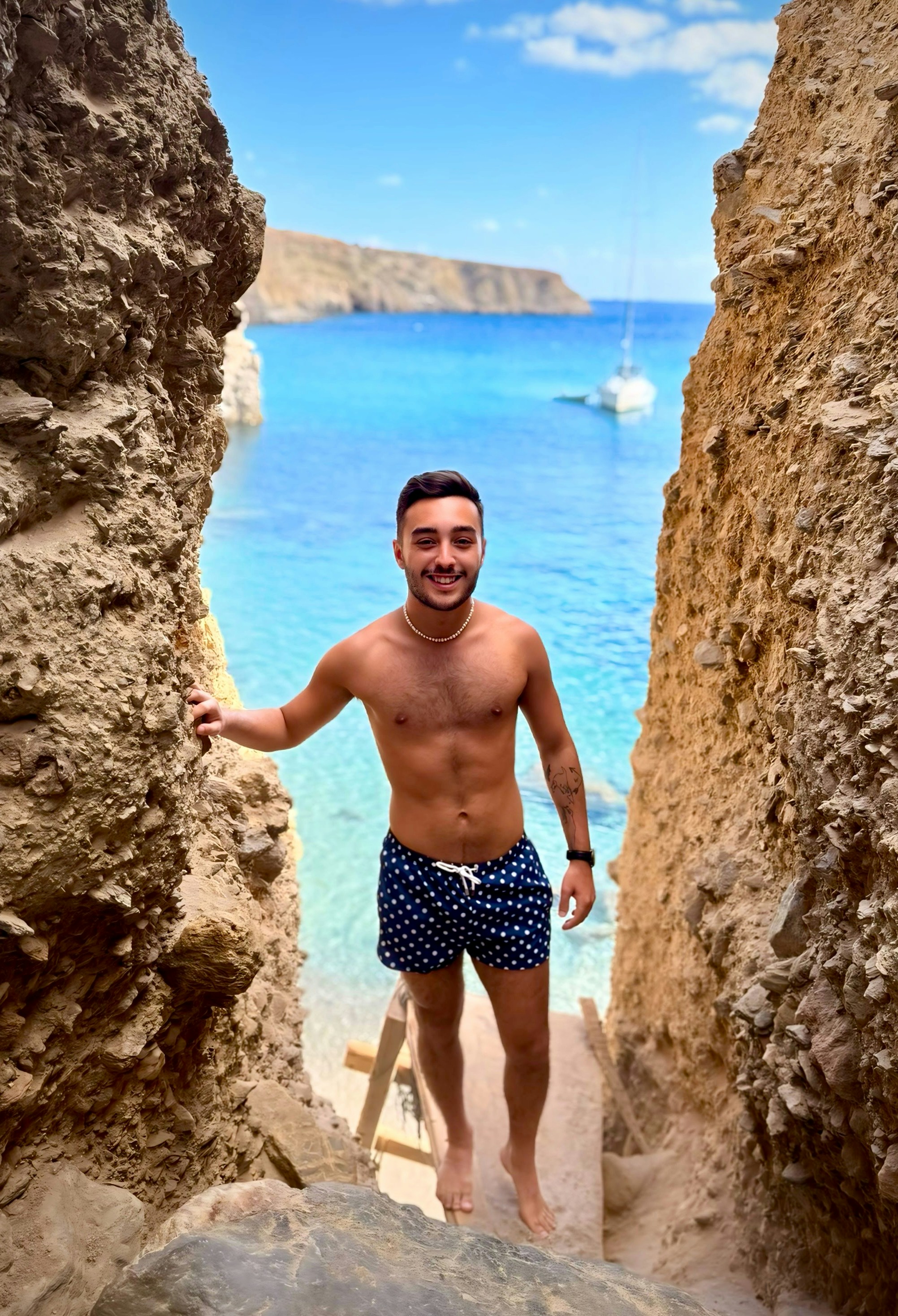 Man standing on stairs by a beautiful blue ocean