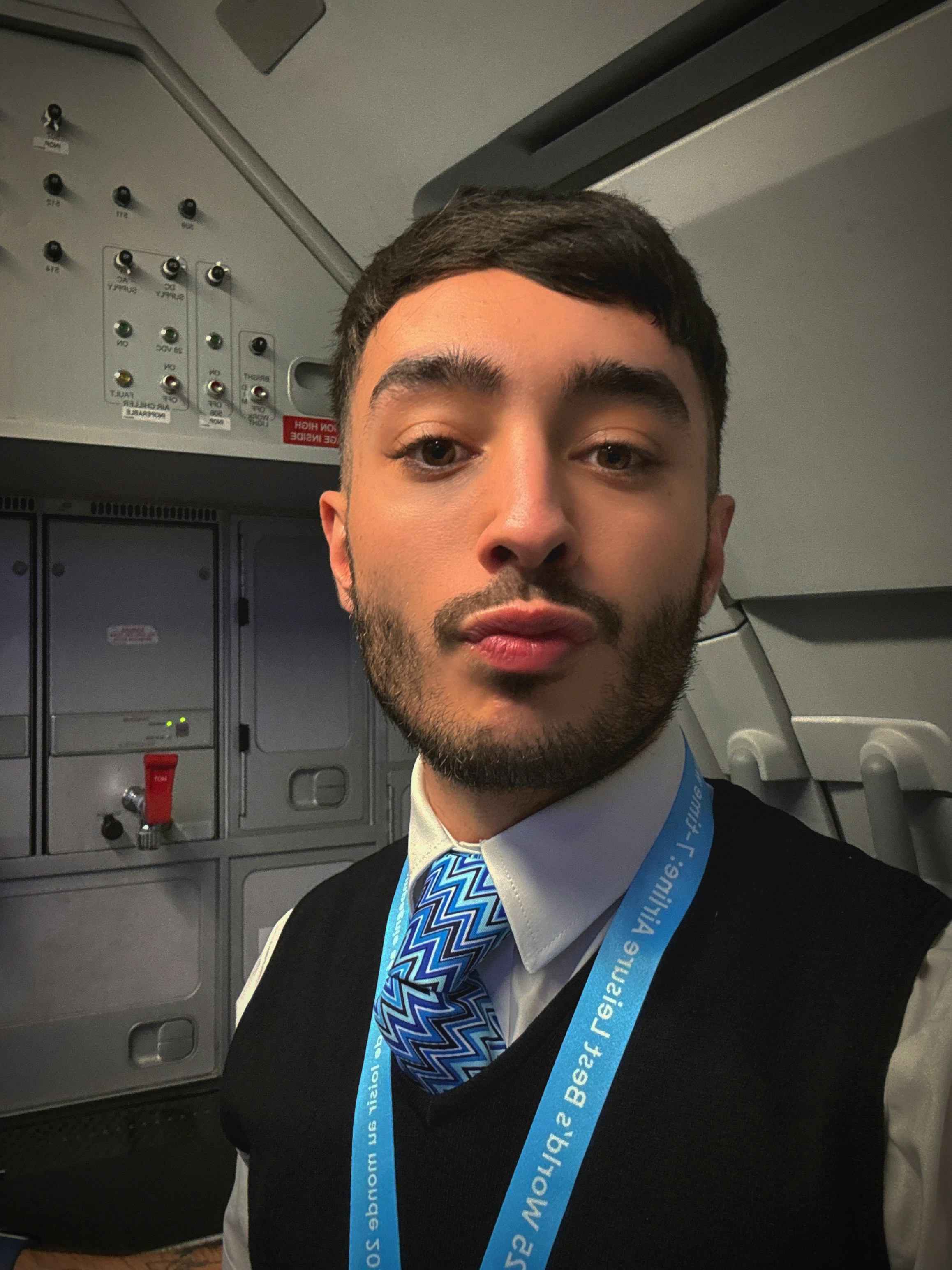 Azafata de vuelo en uniforme frunciendo los labios